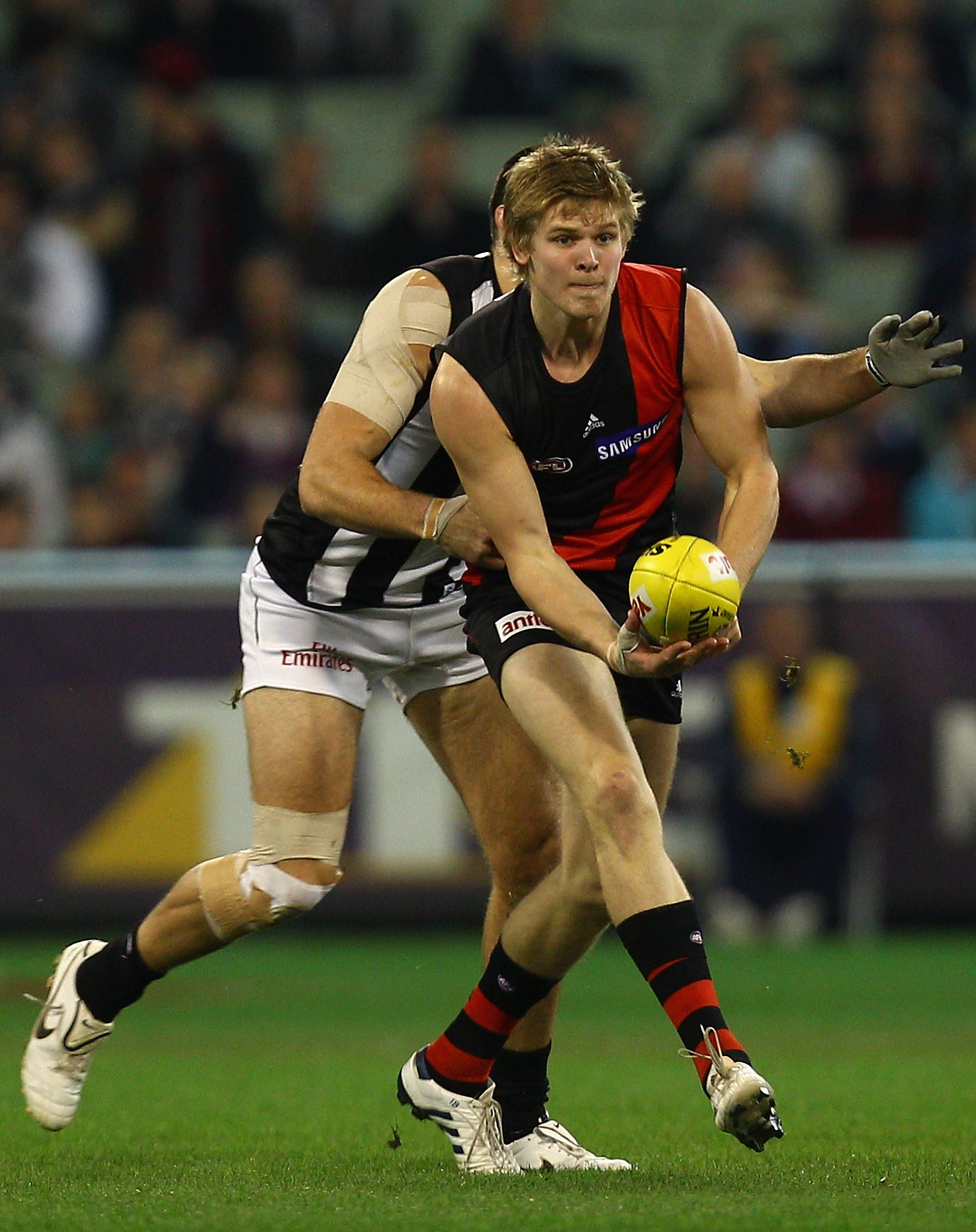 MELBOURNE, AUSTRALIA - AUGUST 13: Michael Hurley of the Bombers handballs during the round 20 AFL match between the Essendon Bombers and the Collingwood Magpies at Melbourne Cricket Ground on August 13, 2010 in Melbourne, Australia. (Photo by Quinn Roon