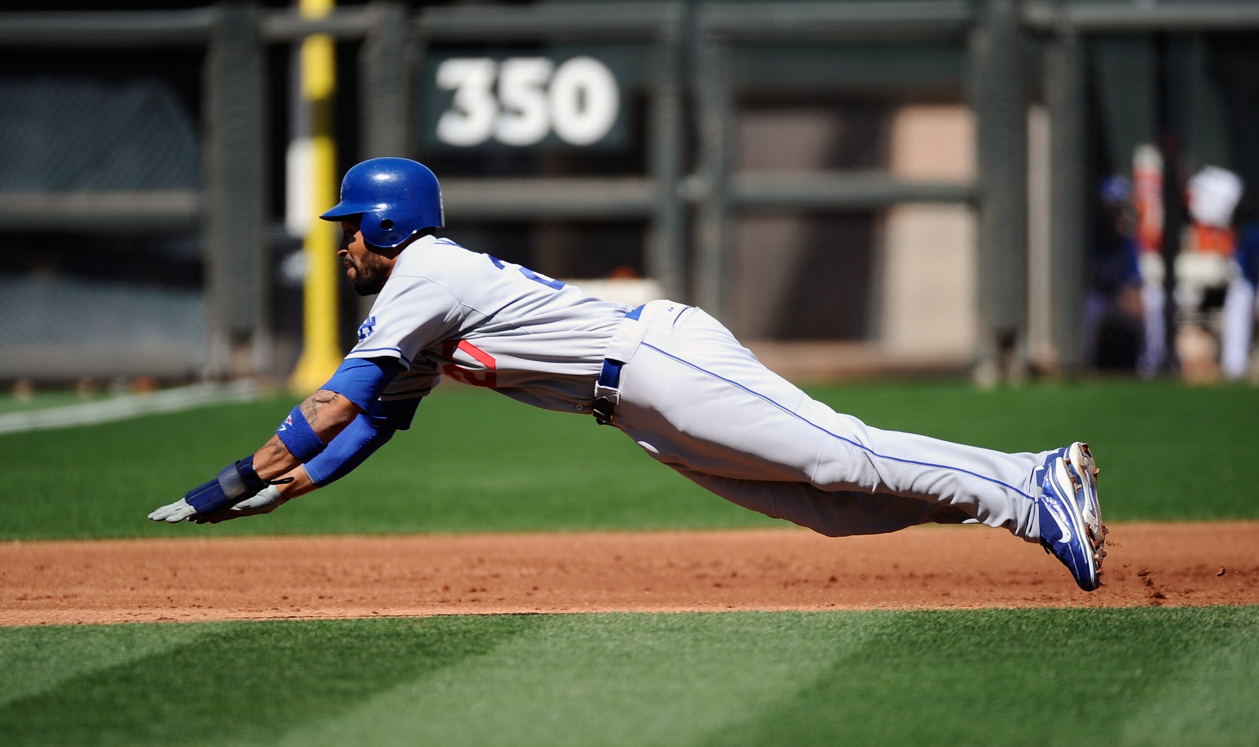 SURPRISE, AZ - MARCH 12: Matt Kemp #27 of the the Los Angeles Dodgers dives into third base to steal during the first inning of the spring training baseball game against the Kansas City Royals  at Surprise Stadium on March 12, 2011 in Surprise, Arizona.