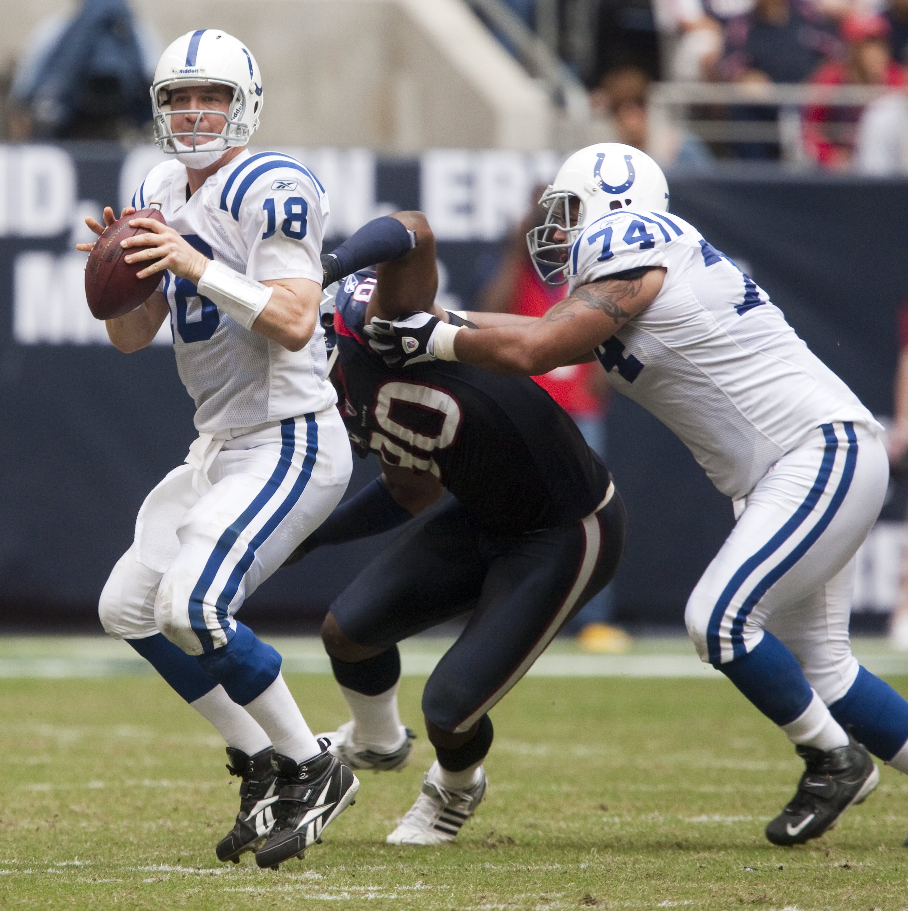 HOUSTON - NOVEMBER 29:  Quarterback Peyton Manning #18 of the Indianapolis Colts looks down-field for a receiver as offensive tackle Charlie Johnson #74 blocks defensive end Mario Williams #90 of the Houston Texans at Reliant Stadium on November 29, 2009