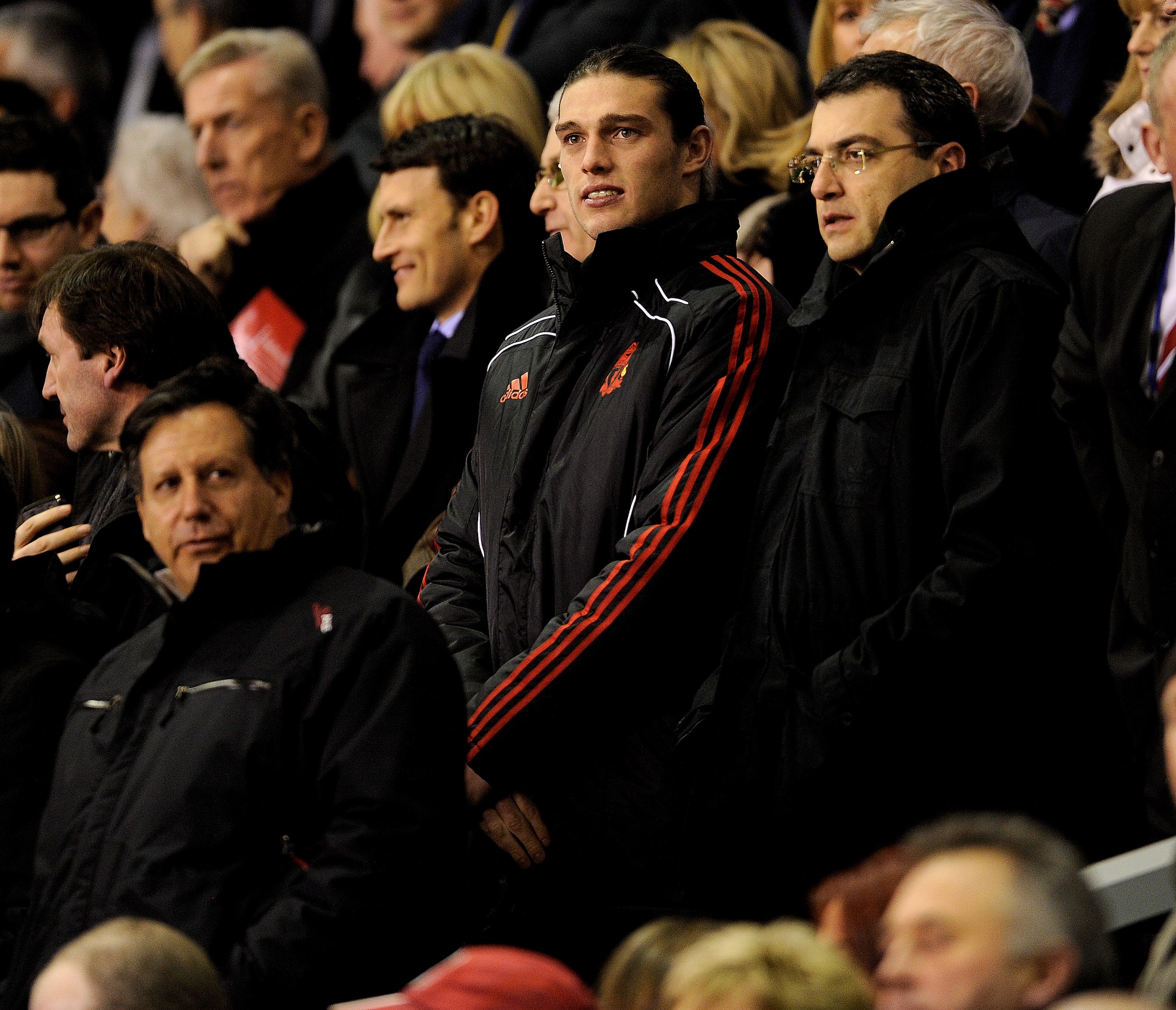 LIVERPOOL, ENGLAND - FEBRUARY 02:  New Liverpool signing Andy Carroll watches from the stands with Chairman Tom Werner (L) and Director of Football Strategy Damien Comolli (R) prior to the Barclays Premier League match between Liverpool and Stoke City at