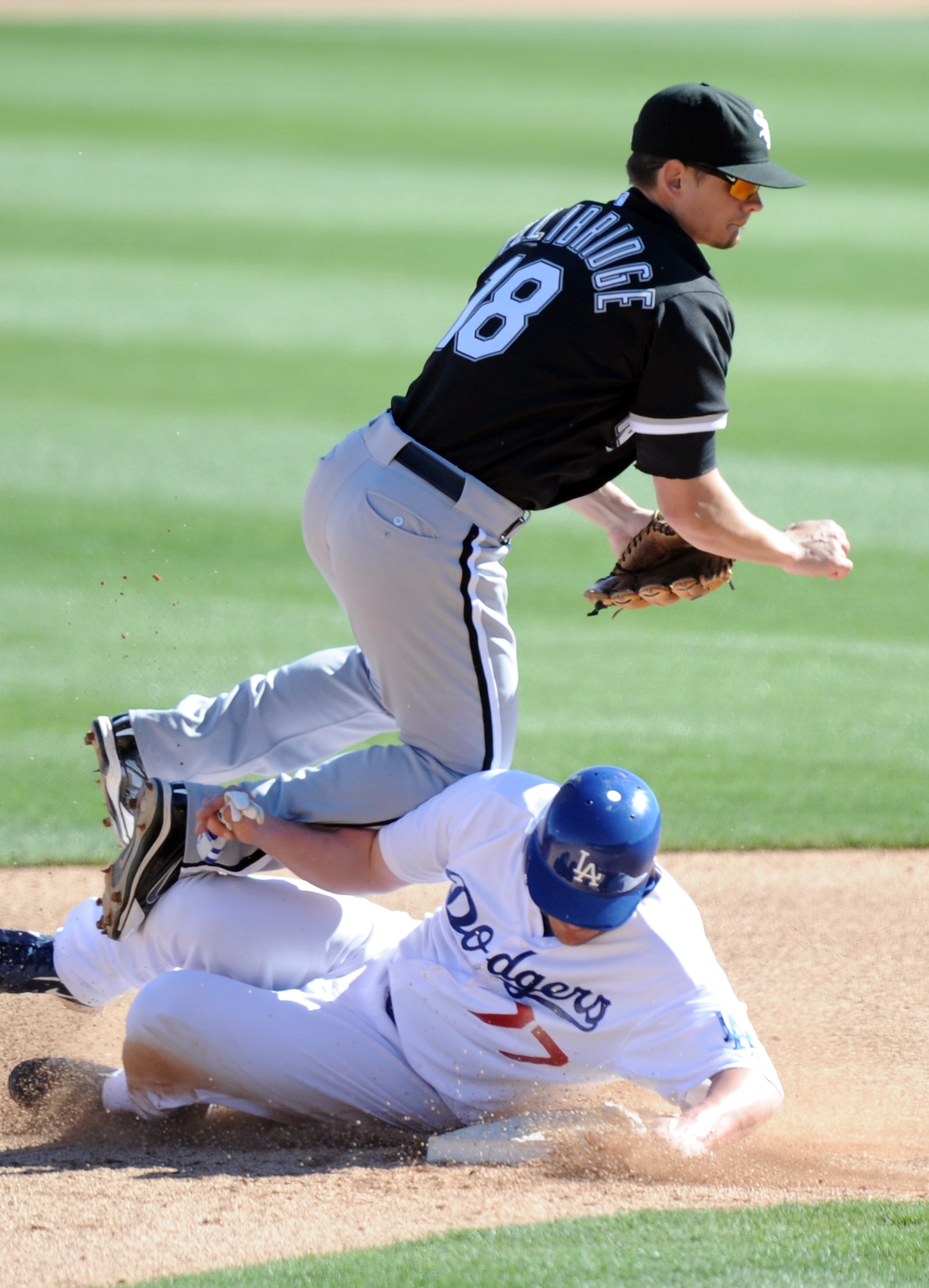 PHOENIX, AZ - FEBRUARY 28:  Brent Lillibridge #18 of the Chicago White Sox turns a double play in front of a sliding JD Closser #77 of the Los Angeles Dodgers in the sixth inning during spring training at Camelback Ranch on February 28, 2011 in Phoenix, A