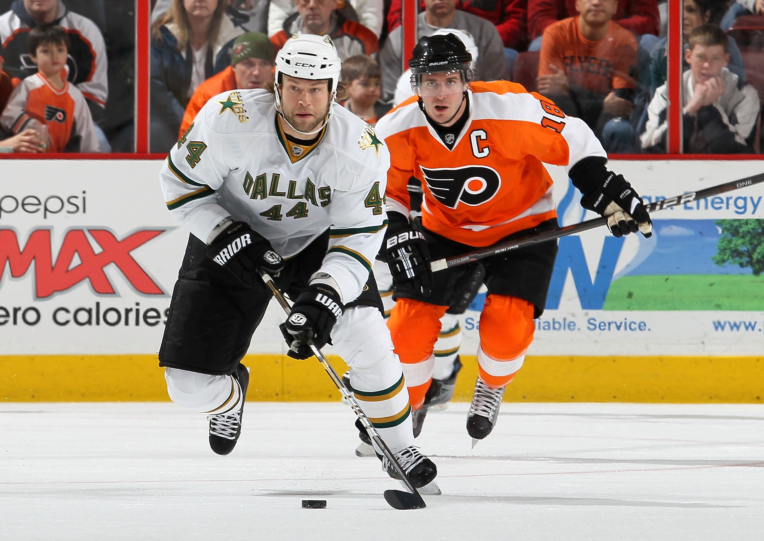 PHILADELPHIA, PA - FEBRUARY 05:  Jeff Woywitka #44 of the Dallas Stars carries to puck up ice against Mike Richards #18 of the Philadelphia Flyers on February 5, 2011 at Wells Fargo Center in Philadelphia, Pennsylvania.  (Photo by Jim McIsaac/Getty Images