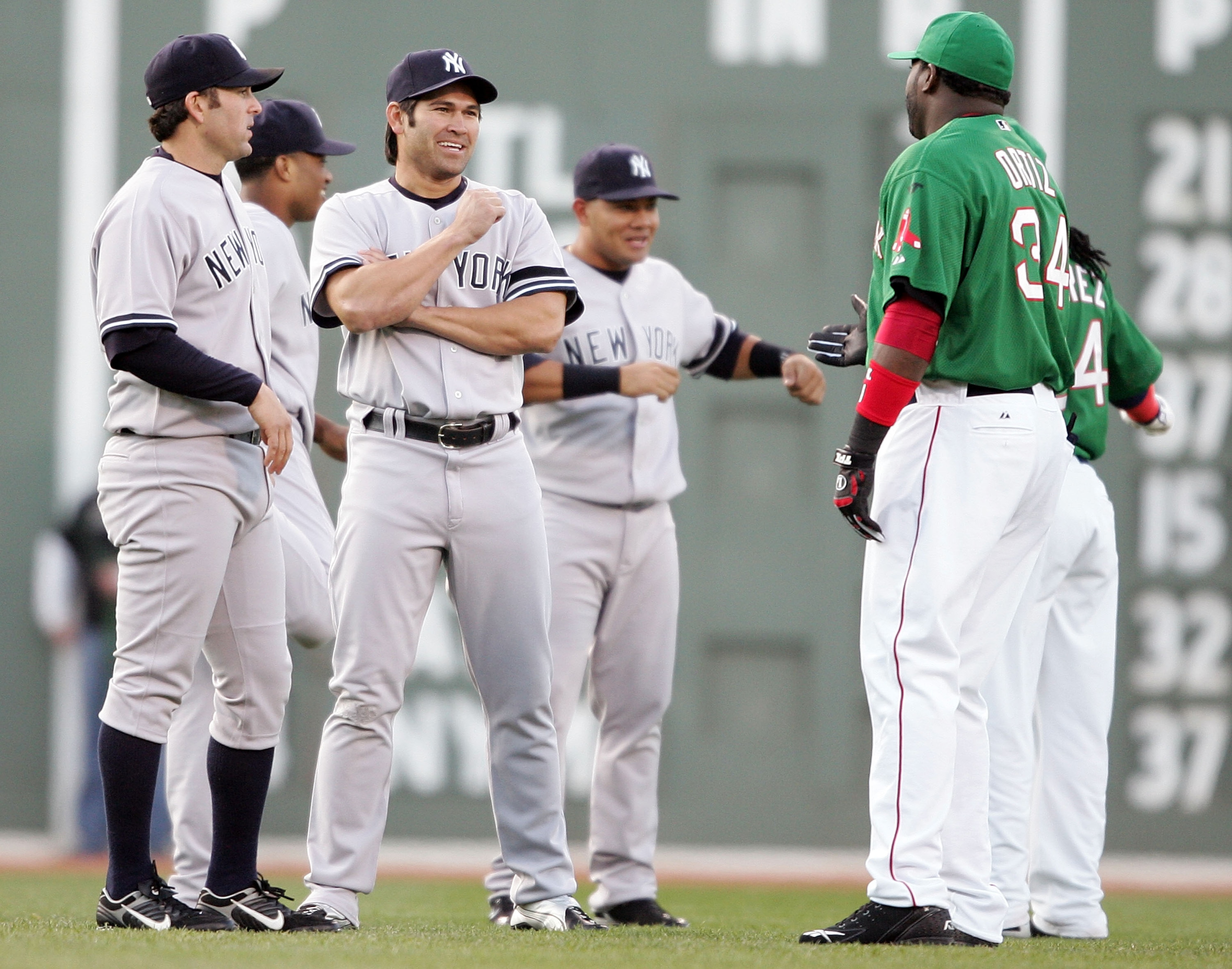 BOSTON - APRIL 20:  Doug Mientkiewicz #11 and Johnny Damon #18 of the New York Yankees catches up with his old teammates David Ortiz #34 and Manny Ramirez #24 of the Boston Red Sox before the game on April 20, 2007 at Fenway Park in Boston, Massachusetts.