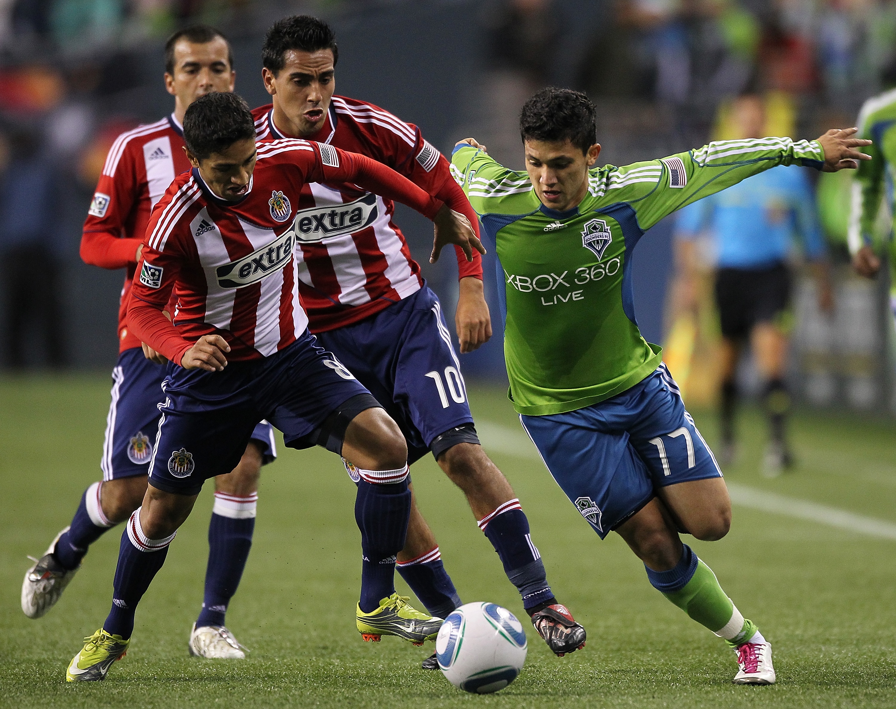 SEATTLE - OCTOBER 15:  Fredy Montero #17 of the Seattle Sounders FC dribbles against Mariano Trujillo #8 and Jesus Padilla #10 of Chivas USA on October 15, 2010 at Qwest Field in Seattle, Washington. (Photo by Otto Greule Jr/Getty Images)