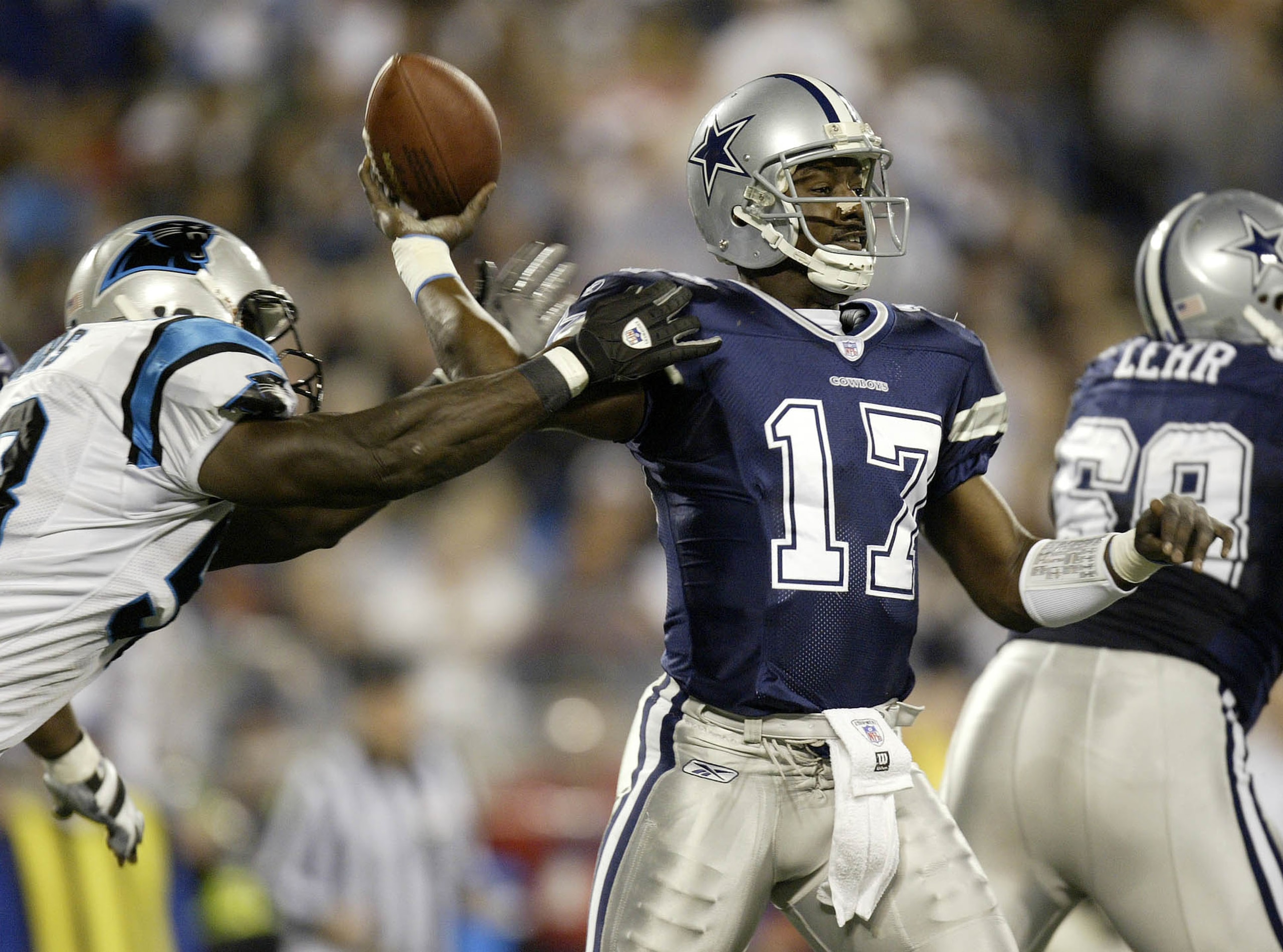 CHARLOTTE, NC - JANUARY 3:  Quincy Carter #17 of the Dallas Cowboys is hit by a Carolina Panthers defender while throwing a pass during their NFC Wildcard playoff game on January 3, 2004 at Ericsson Stadium in Charlotte, North Carolina.  (Photo By Craig J