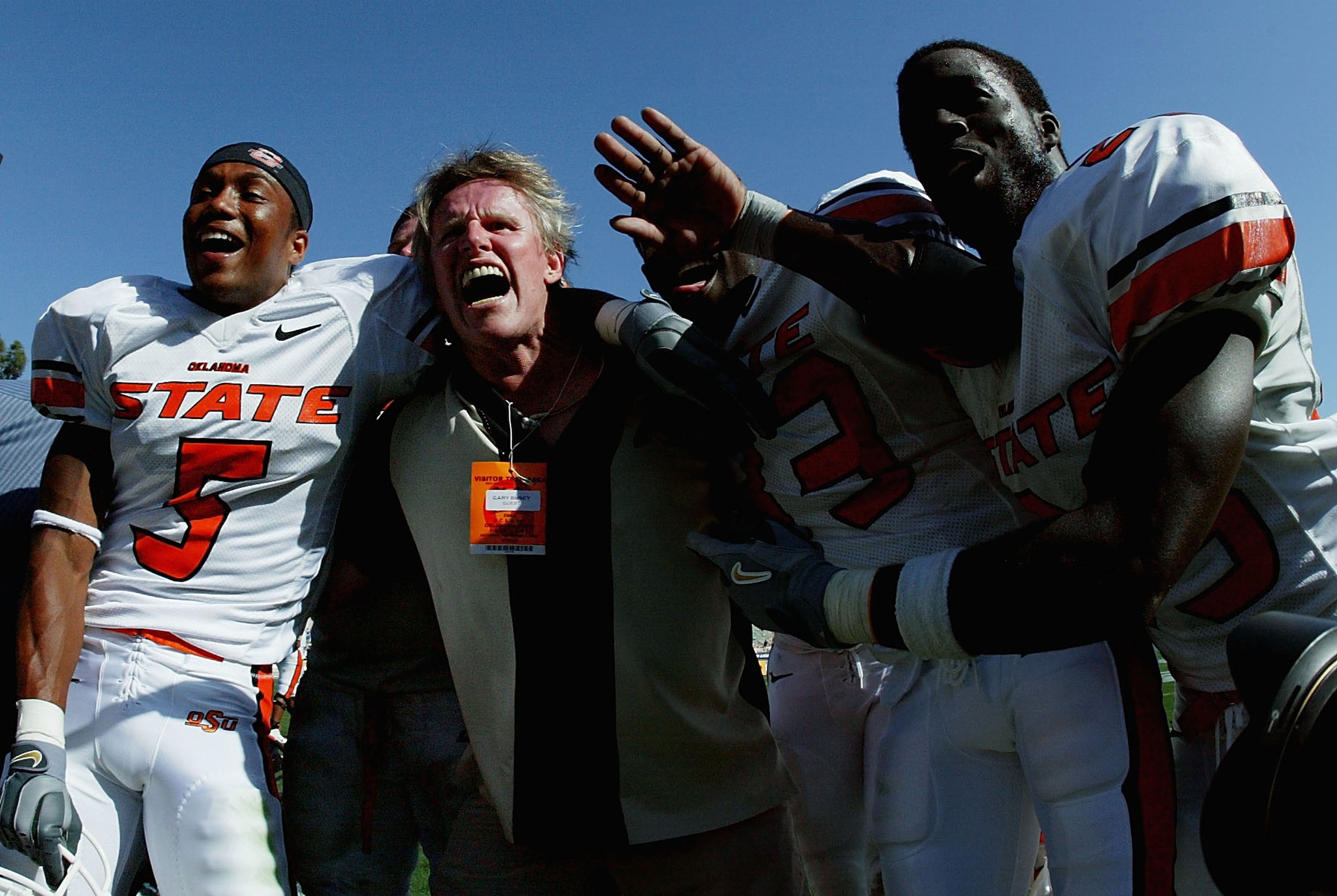 PASADENA, CA - SEPTEMBER 4:  Actor Gary Busey celebrates with victory with cornerback Ricky Coxeff #5 and wide receiver Chijuan Mack #83 of the Oklahoma State Cowboys and other teammates after defeating the UCLA Bruins on September 4, 2004 at the Rose Bow