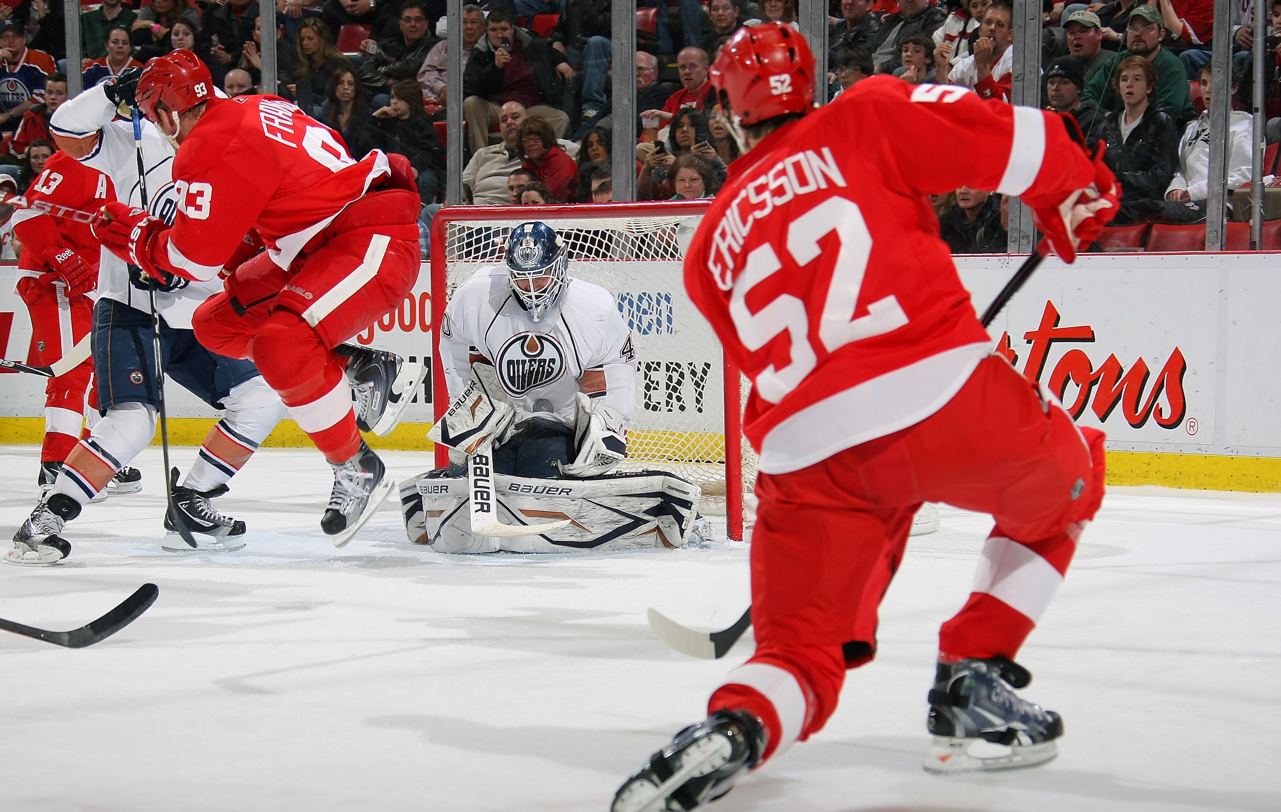 DETROIT, MI - MARCH 11:  Devan Dubnyk #40 of the Edmonton Oilers makes a save on Jonathan Ericsson #52 of the Detroit Red Wings as Johan Franzen #93 of the Red Wings jumps in front of the net during their NHL game at Joe Louis Arena on March 11, 2011 in D