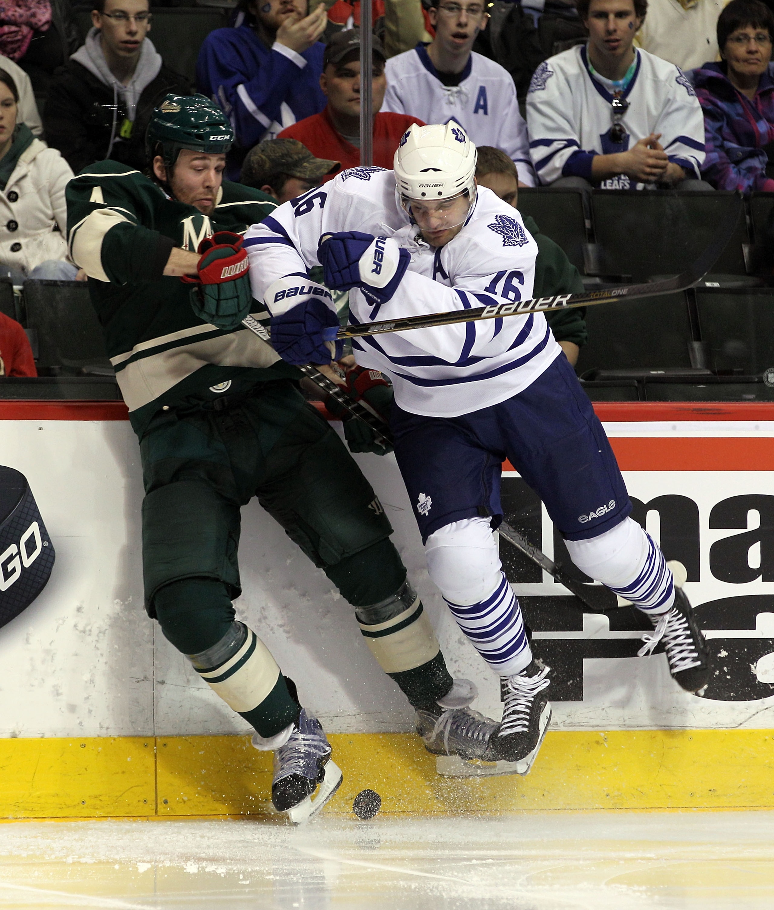 ST PAUL, MN - MARCH 22:  Clayton Stoner #4 of the Minnesota Wild is run into by Clarke MacArthur #16 of the Toronto Maple Leafs at the Xcel Energy Center on March 22, 2011 in St Paul, Minnesota. The Maple Leafs shut out the Wild 3-0.  (Photo by Bruce Benn