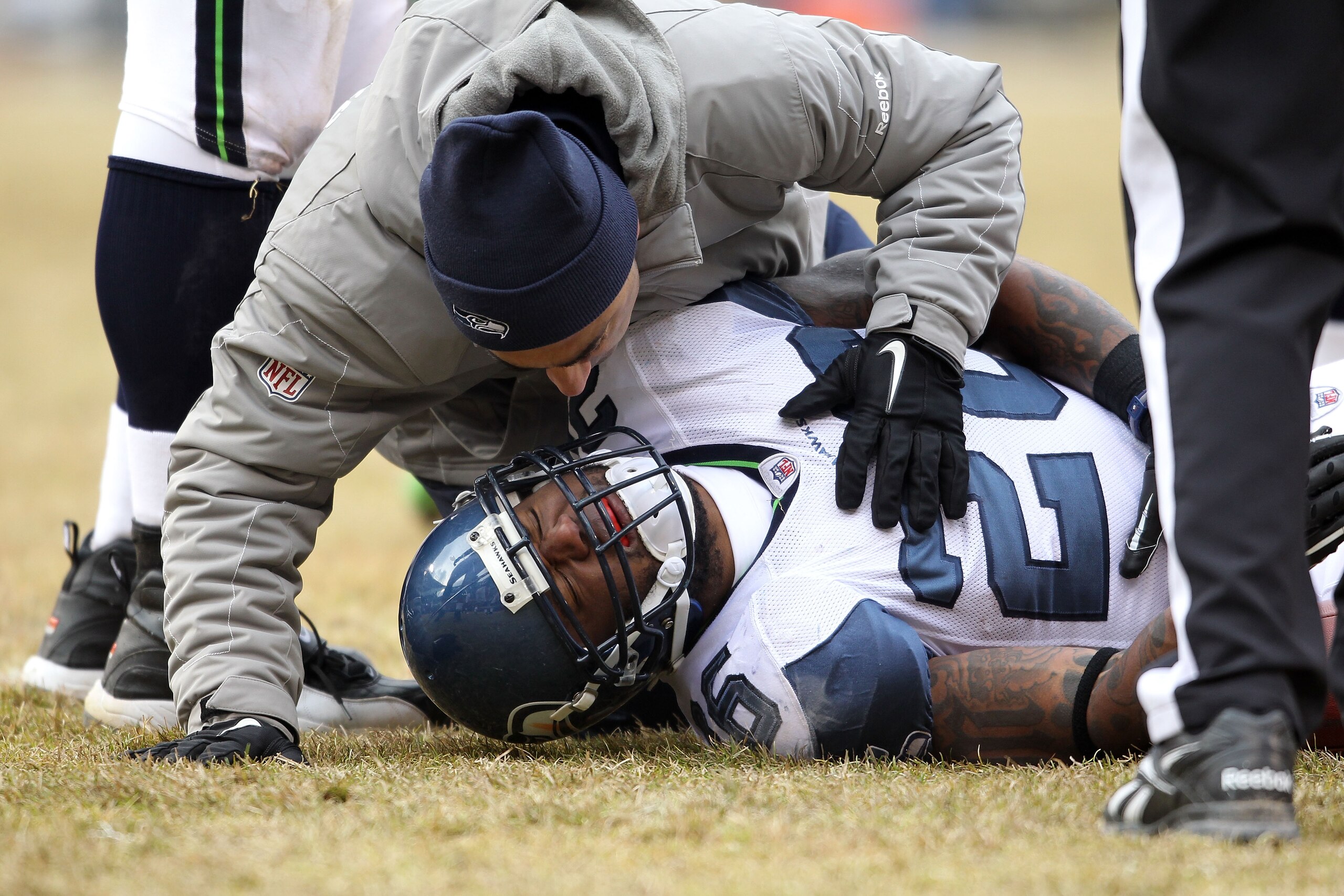 CHICAGO, IL - JANUARY 16:  Michael Robinson #26 of the Seattle Seahawks is checked on by a trainer after an injury in the second half against the Chicago Bears in the 2011 NFC divisional playoff game at Soldier Field on January 16, 2011 in Chicago, Illino
