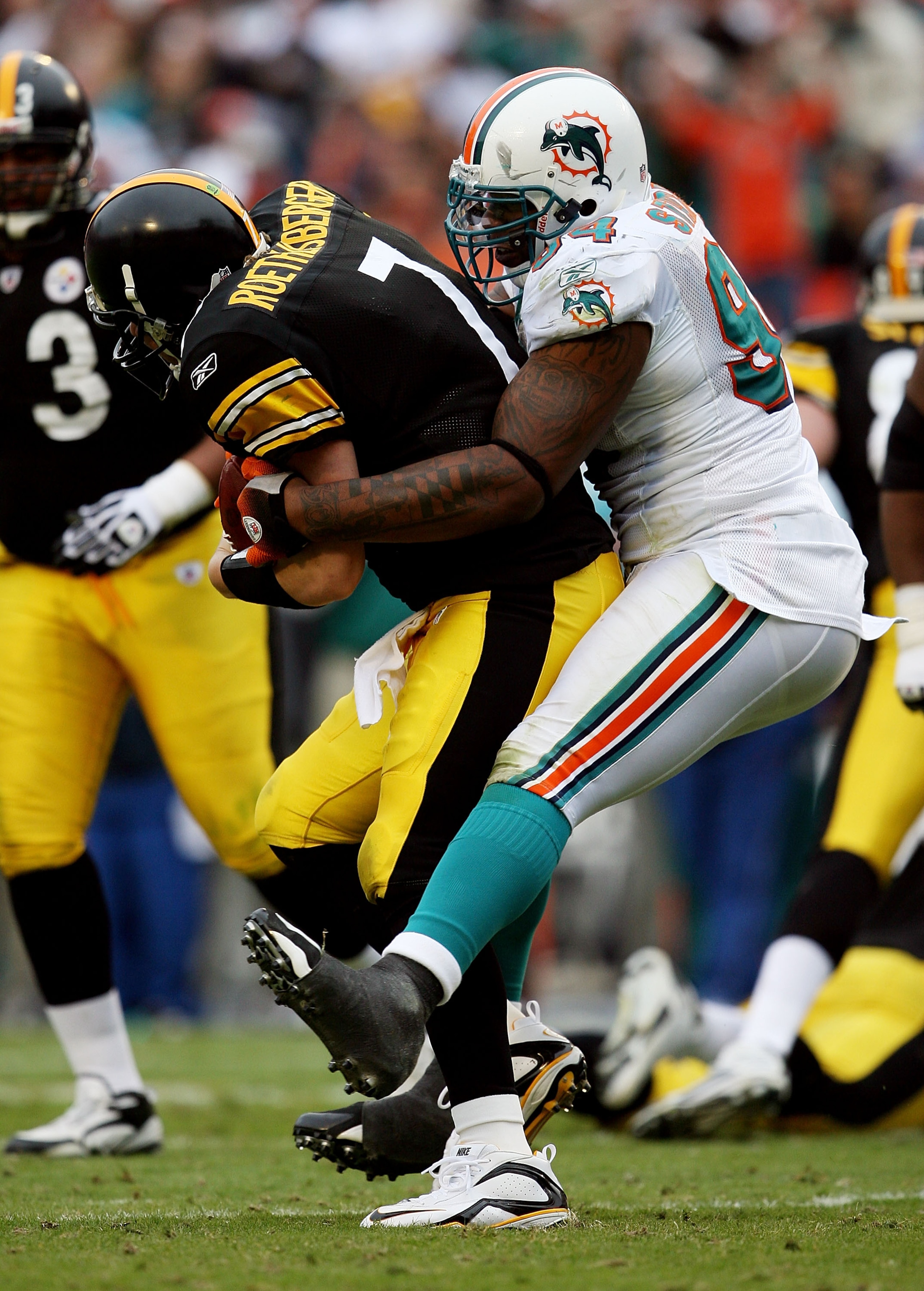 MIAMI - JANUARY 03:  Quarterback Ben Roethlisberger #7 of the Pittsburgh Steelers is sacked by defensive end Randy Starks #94 of the Miami Dolphins at Land Shark Stadium on January 3, 2010 in Miami, Florida. The Steelers defeated the Dolphins 30-24.  (Pho