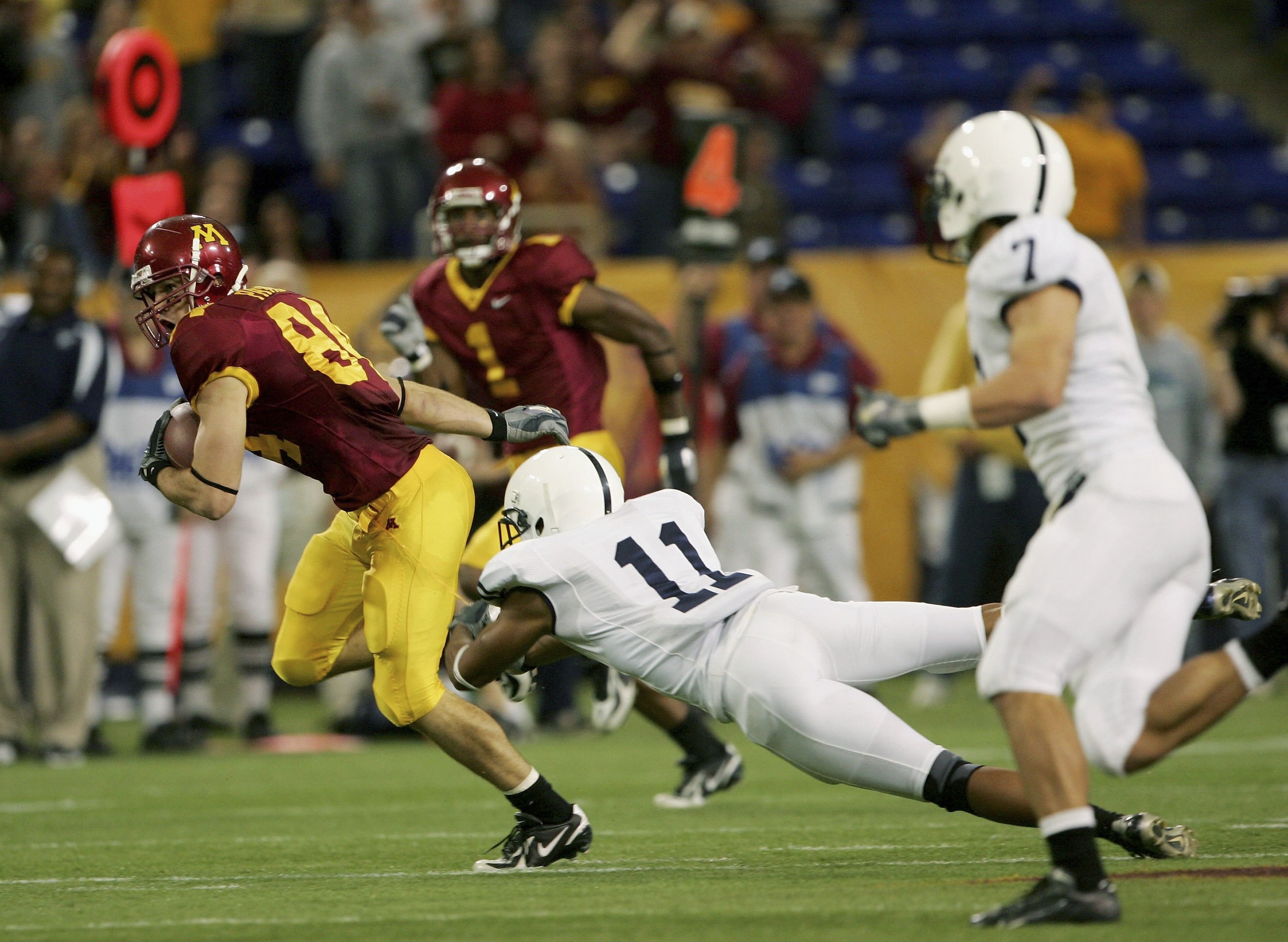 MINNEAPOLIS, MN - OCTOBER 07:  Wide receiver Logan Payne #84 of the Minnesota Golden Gophers eludes Tony Davis #11 of the Penn State Nittany Lions as he went 42 yards on 4th and 3 in the fourth quarter to help set up the game tieing touchdown on October 7