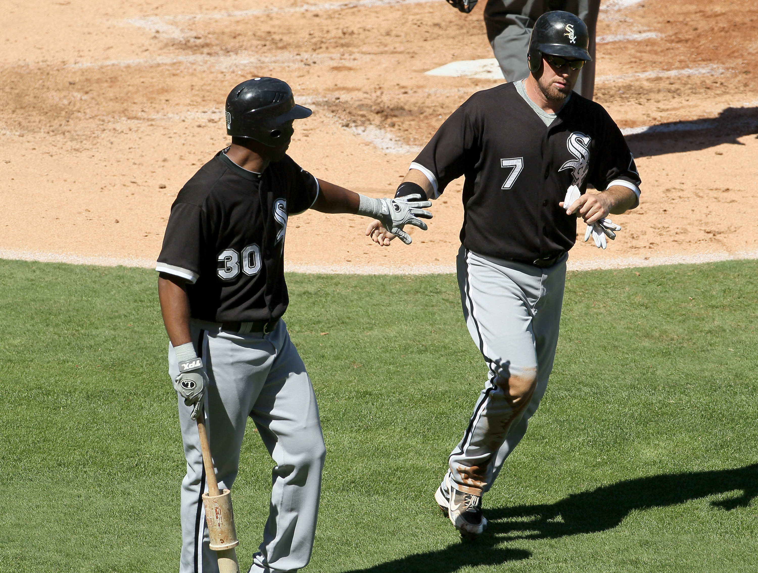 ANAHEIM, CA - SEPTEMBER 26:  Mark Kotsay #7 of the Chicago White Sox is greeted by Alejandro De Aza #30 after scoring on a sacrifice fly in the second inning against the Los Angeles Angels of Anaheim in the second inning on September 26, 2010 at Angel Sta