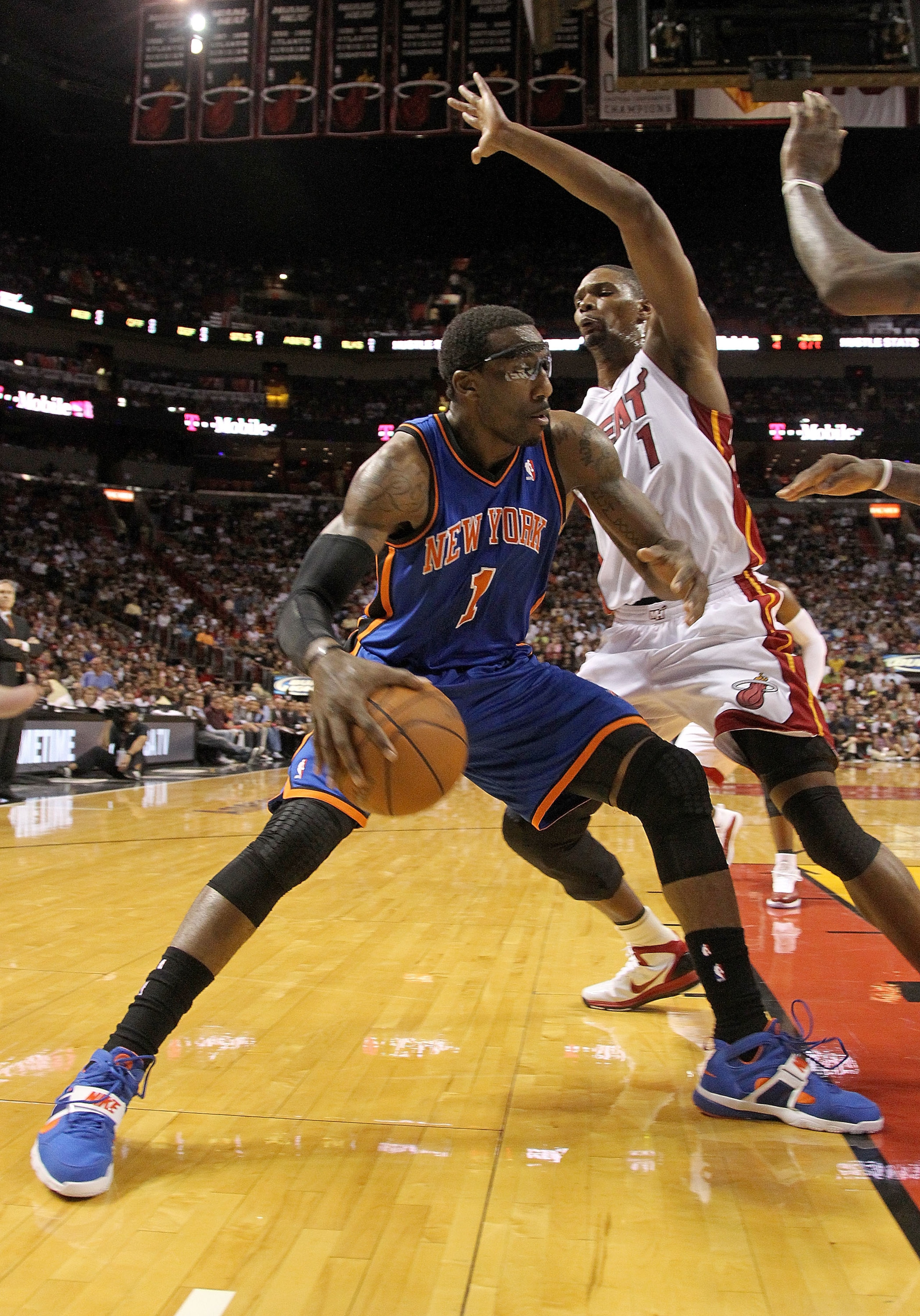 MIAMI, FL - FEBRUARY 27:  Amar'e Stoudemire #1 of the New York Knicks posts up Chris Bosh #1 of the Miami Heat during a game at American Airlines Arena on February 27, 2011 in Miami, Florida. NOTE TO USER: User expressly acknowledges and agrees that, by d
