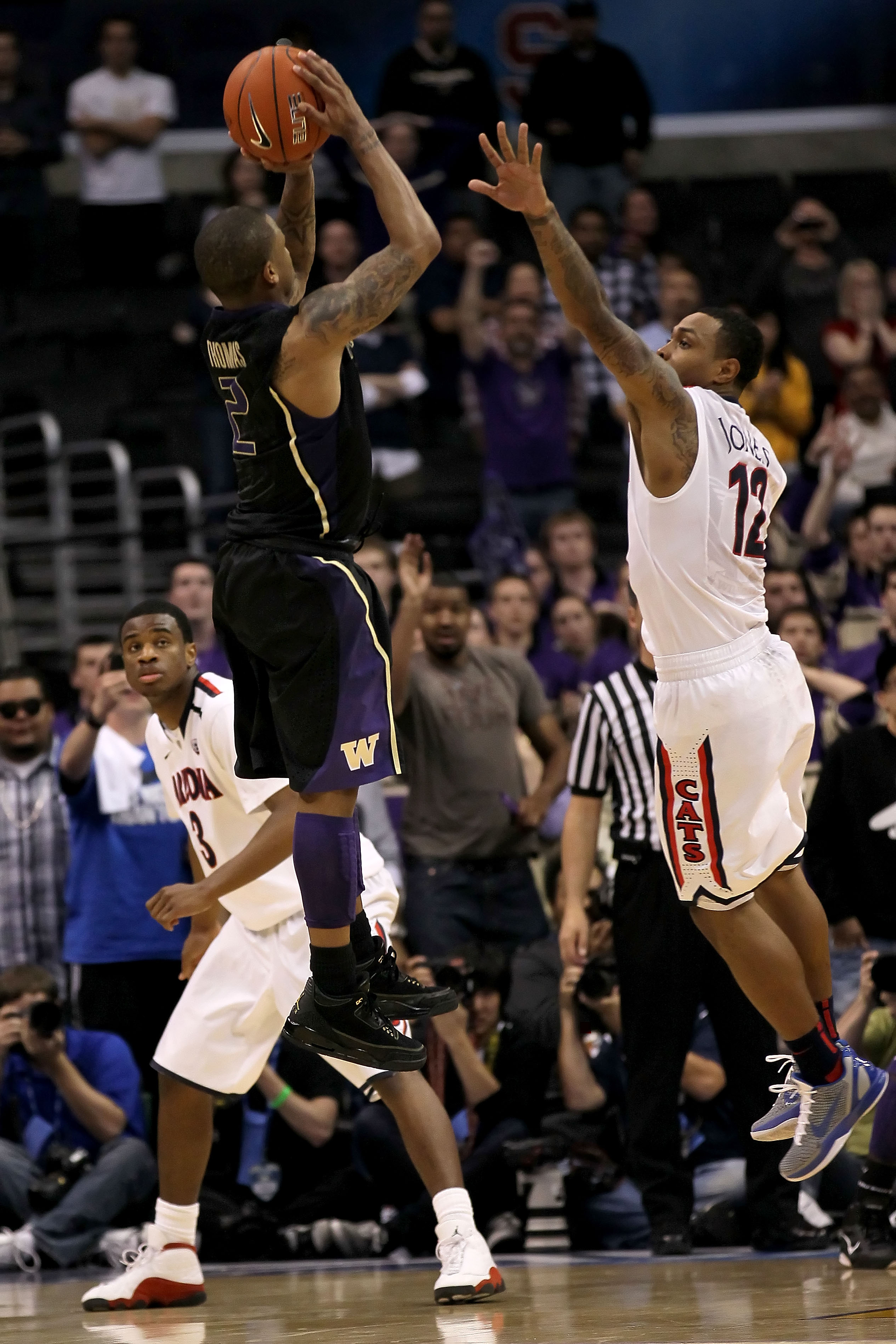 LOS ANGELES, CA - MARCH 12: Isaiah Thomas #2 of the Washington Huskies makes a last-second shot in overtime over the arm of Lamont Jones #12 of the Arizona Wildcats to lead the Huskies to a 77-75 victory in the championship game of the 2011 Pacific Life