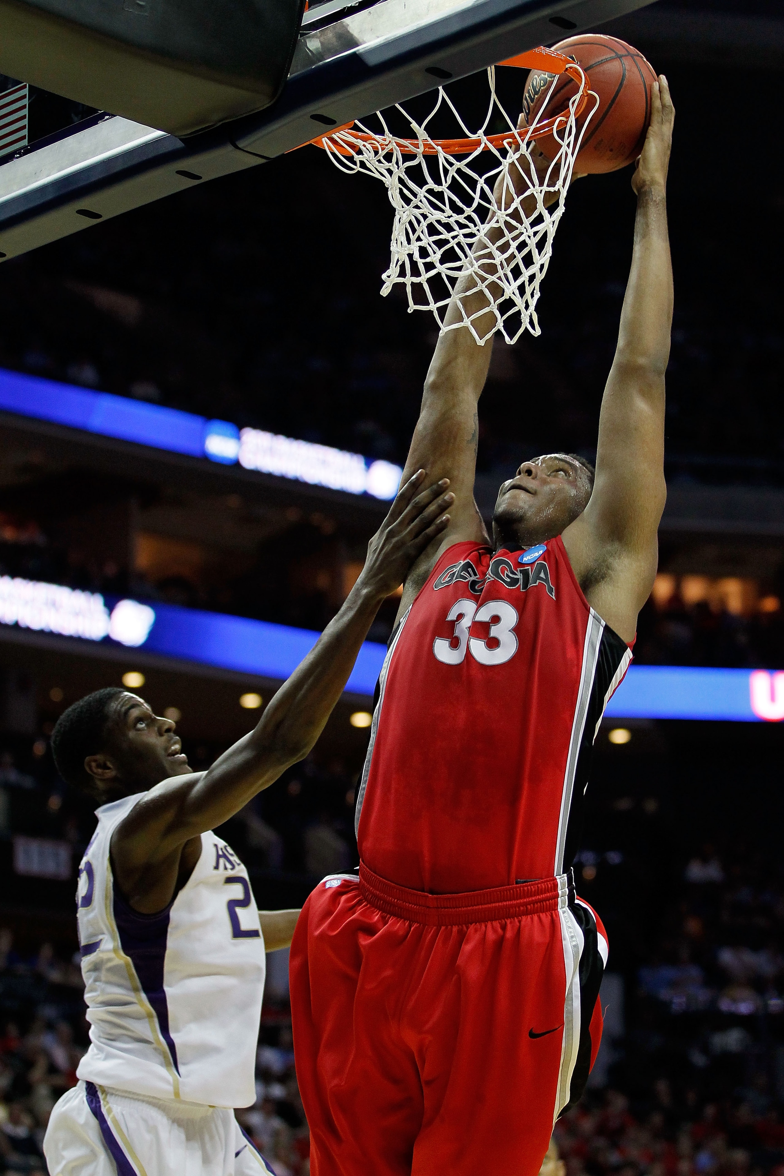 CHARLOTTE, NC - MARCH 18:  Trey Thompkins #33 of the Georgia Bulldogs goes up for a dunk over Justin Holiday #22 of the Washington Huskies in the first half during the second round of the 2011 NCAA men's basketball tournament at Time Warner Cable Arena on