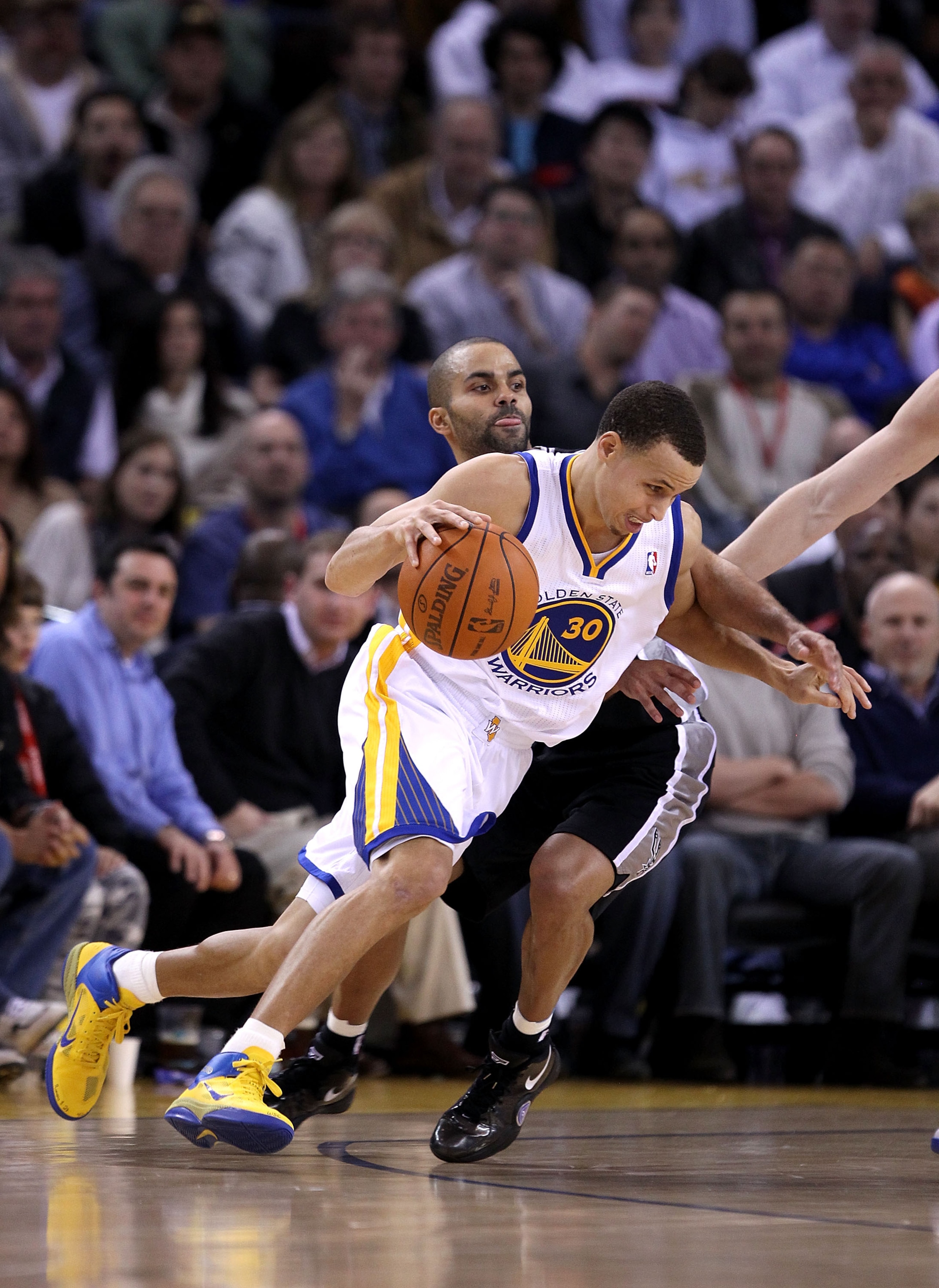 OAKLAND, CA - JANUARY 24:  Stephen Curry #30 of the Golden State Warriors drives on Tony Parker #9 of the San Antonio Spurs at Oracle Arena on January 24, 2011 in Oakland, California.  NOTE TO USER: User expressly acknowledges and agrees that, by download