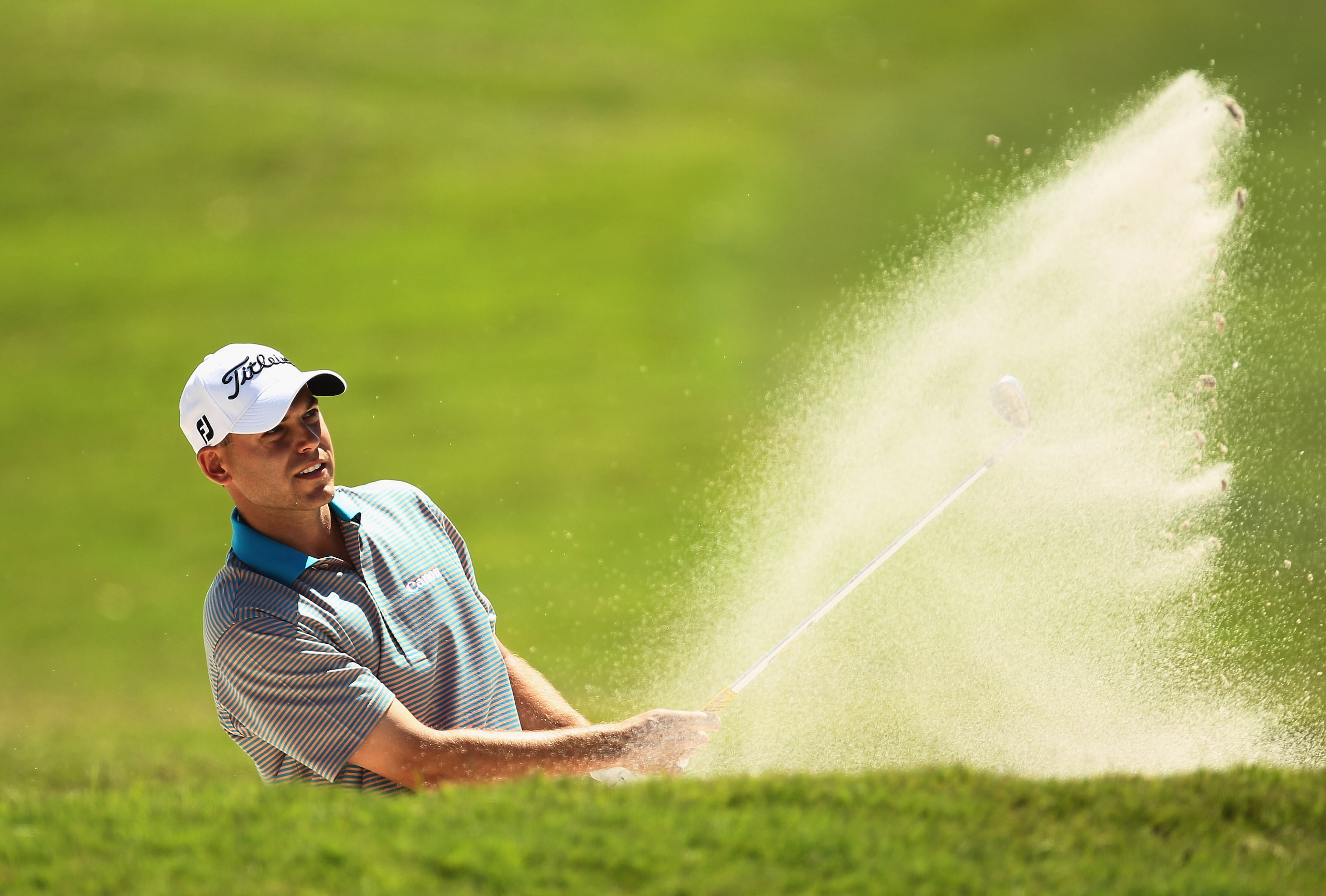 DORAL, FL - MARCH 12:  Bill Haas hits a bunker shot on the first hole during the third round of the 2011 WGC- Cadillac Championship at the TPC Blue Monster at the Doral Golf Resort and Spa on March 12, 2011 in Doral, Florida.  (Photo by Mike Ehrmann/Getty