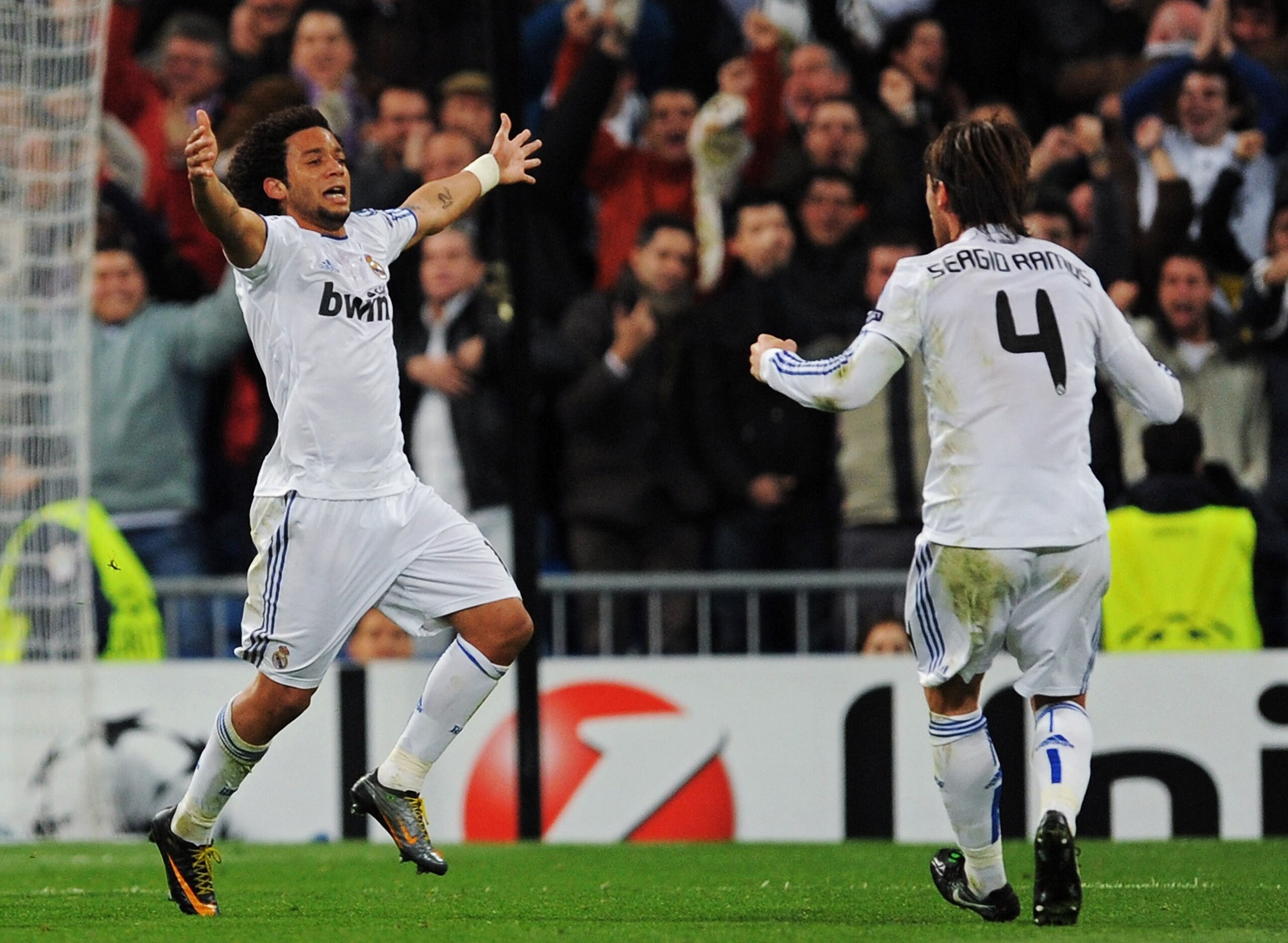 MADRID, SPAIN - MARCH 16:  Marcelo Vieira of Real Madrid celebrates with Sergio Ramos after scoring Real's opening goal during the UEFA Champions League round of 16 second leg match between Real Madrid and Lyon at Estadio Santiago Bernabeu on March 16, 20