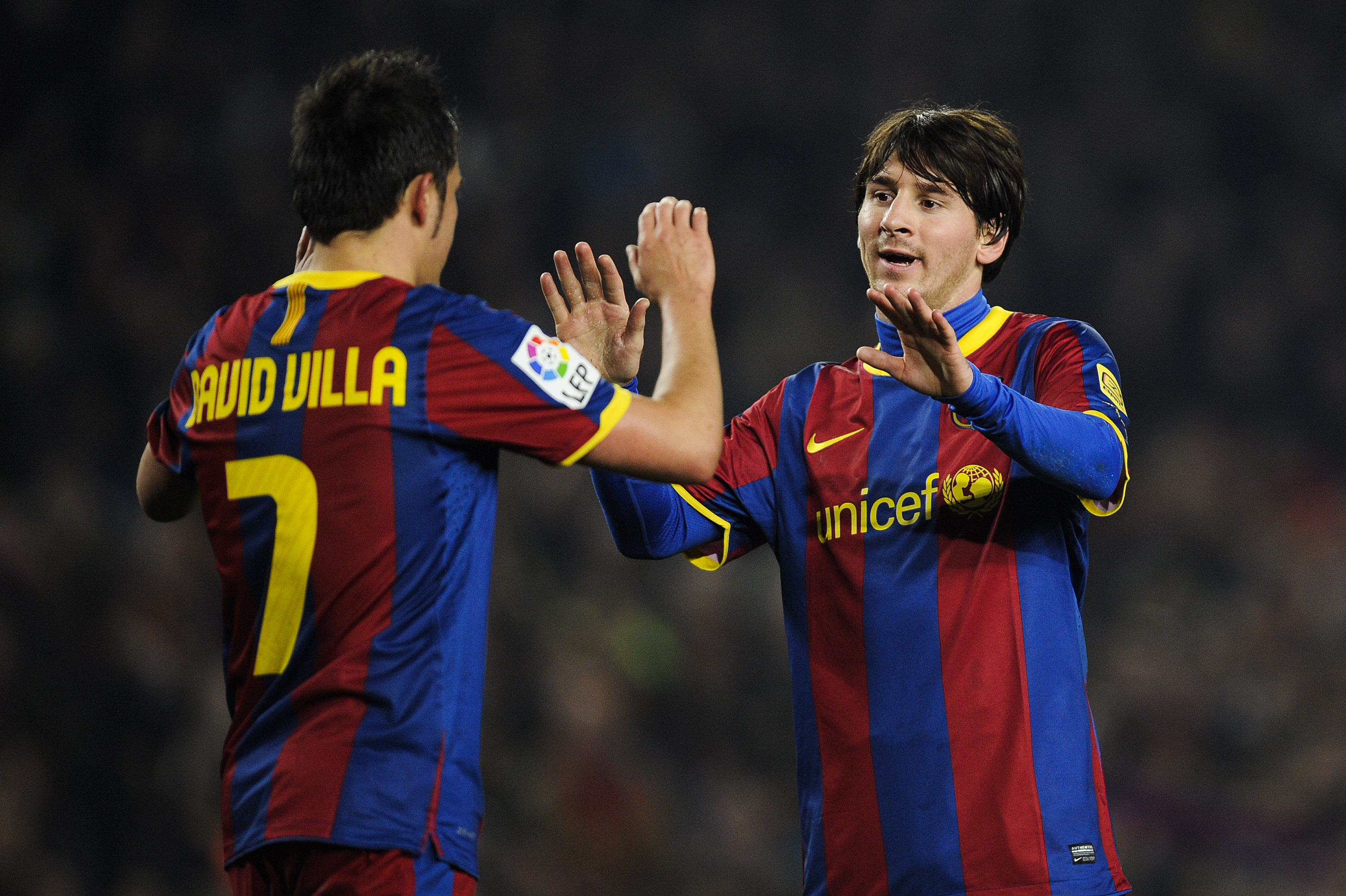 BARCELONA, SPAIN - FEBRUARY 05:  Lionel Messi of Barcelona (R) celebrates with his teammate David Villa after scoring his third goal during the La Liga match between Barcelona and Atletico de Madrid at Camp Nou on February 5, 2011 in Barcelona, Spain.  (P