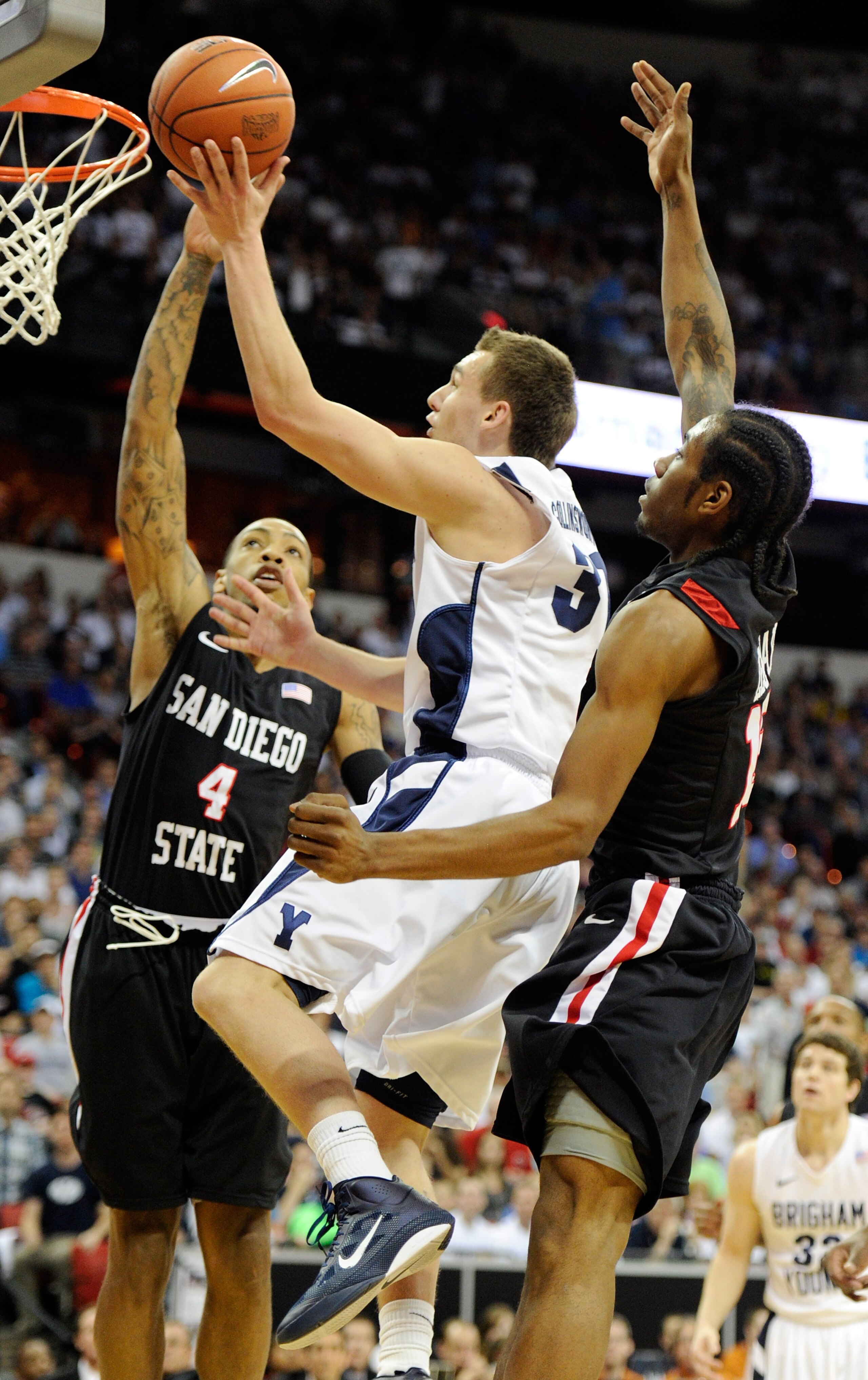 LAS VEGAS, NV - MARCH 12:  Kyle Collinsworth #31 of the Brigham Young University Cougars shoots against Malcolm Thomas #4 and Kawhi Leonard #15 of the San Diego State Aztecs during the championship game of the Conoco Mountain West Conference Basketball to