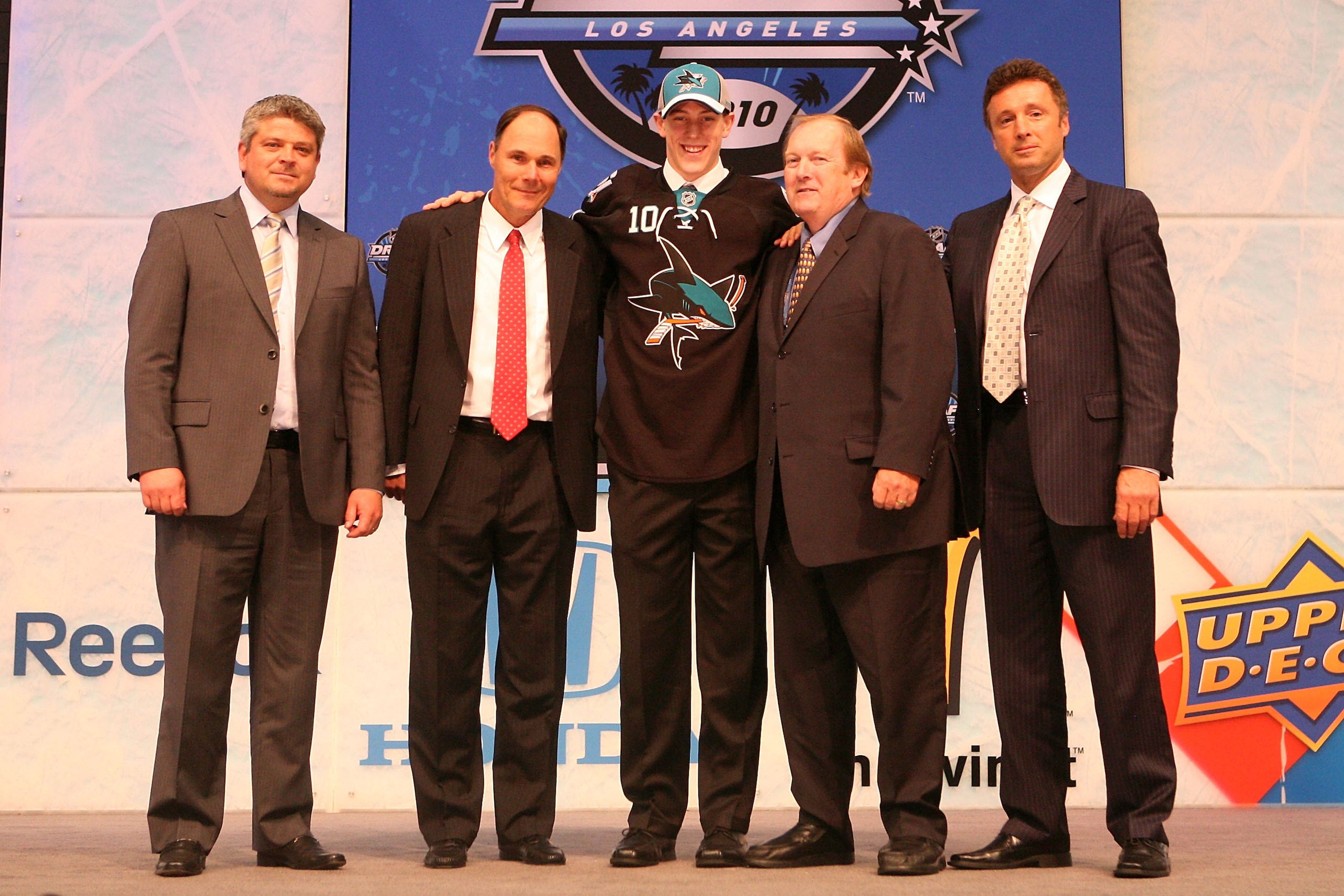 LOS ANGELES, CA - JUNE 25:  Charlie Coyle, drafted 28th overall by the San Jose Sharks, stands on stage with team personnel during the 2010 NHL Entry Draft at Staples Center on June 25, 2010 in Los Angeles, California.  (Photo by Bruce Bennett/Getty Image