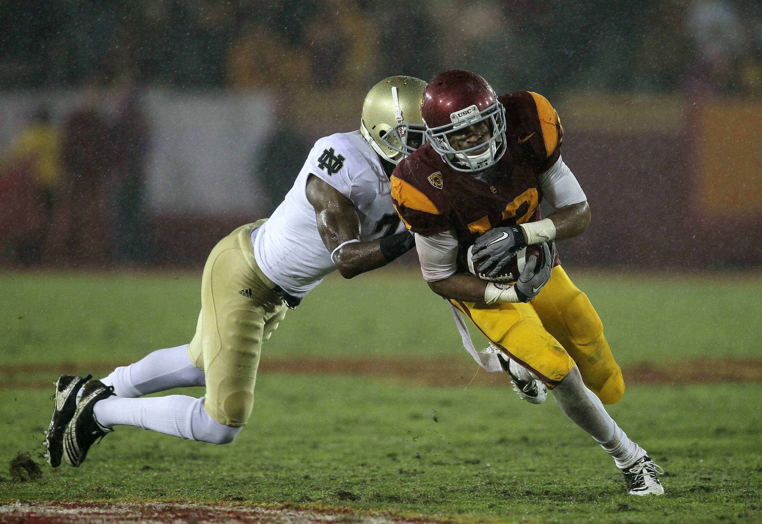 LOS ANGELES - NOVEMBER 27:  Wide receiver Robert Woods #13 of the USC Trojans carries the ball against cornerback Darrin Walls #2 of the Notre Dame Fighting Irish at the Los Angeles Memorial Coliseum on November 27, 2010 in Los Angeles, California.  Notre