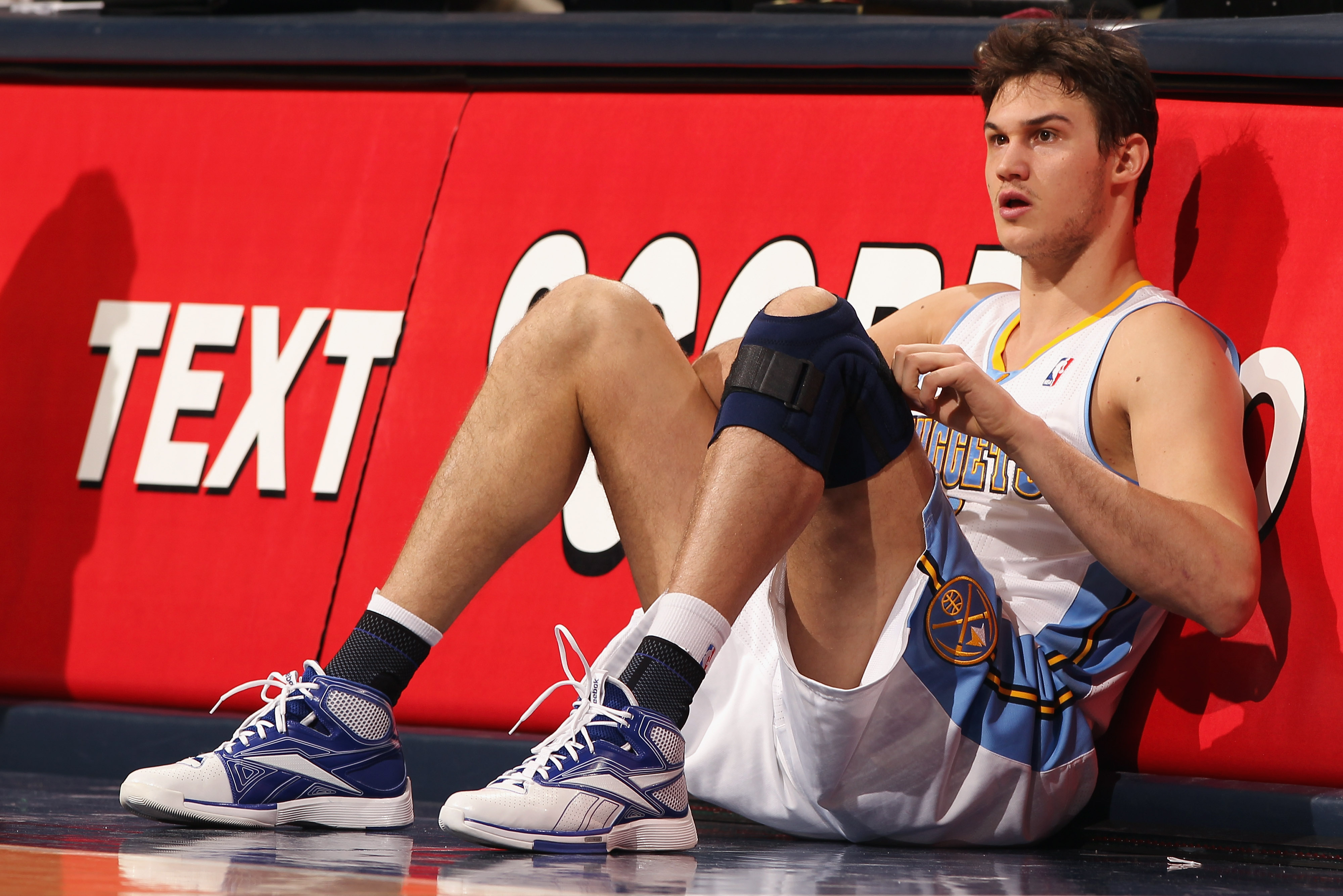 DENVER, CO - FEBRUARY 24:  Danilo Gallinari #8 of the Denver Nuggets adjusts his knee brace as he prepares to reenter the game against the Boston Celtics during NBA action at the Pepsi Center on February 24, 2011 in Denver, Colorado. The Nuggets defeated