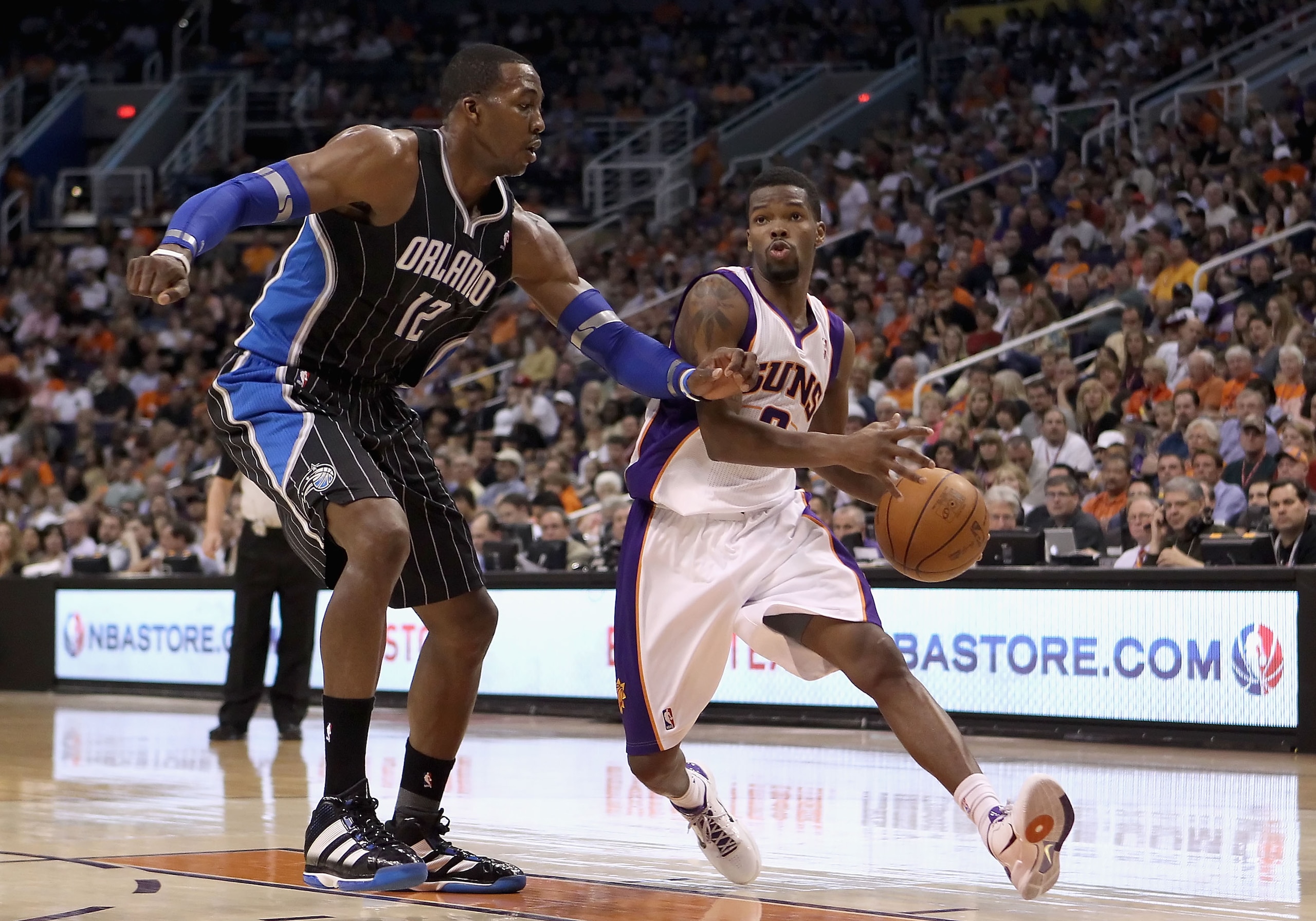 PHOENIX, AZ - MARCH 13:  Aaron Brooks #0 of the Phoenix Suns drives the ball past Dwight Howard #12 of the Orlando Magic during the NBA game at US Airways Center on March 13, 2011 in Phoenix, Arizona.  The Magic defeated the Suns 111-88. NOTE TO USER: Use