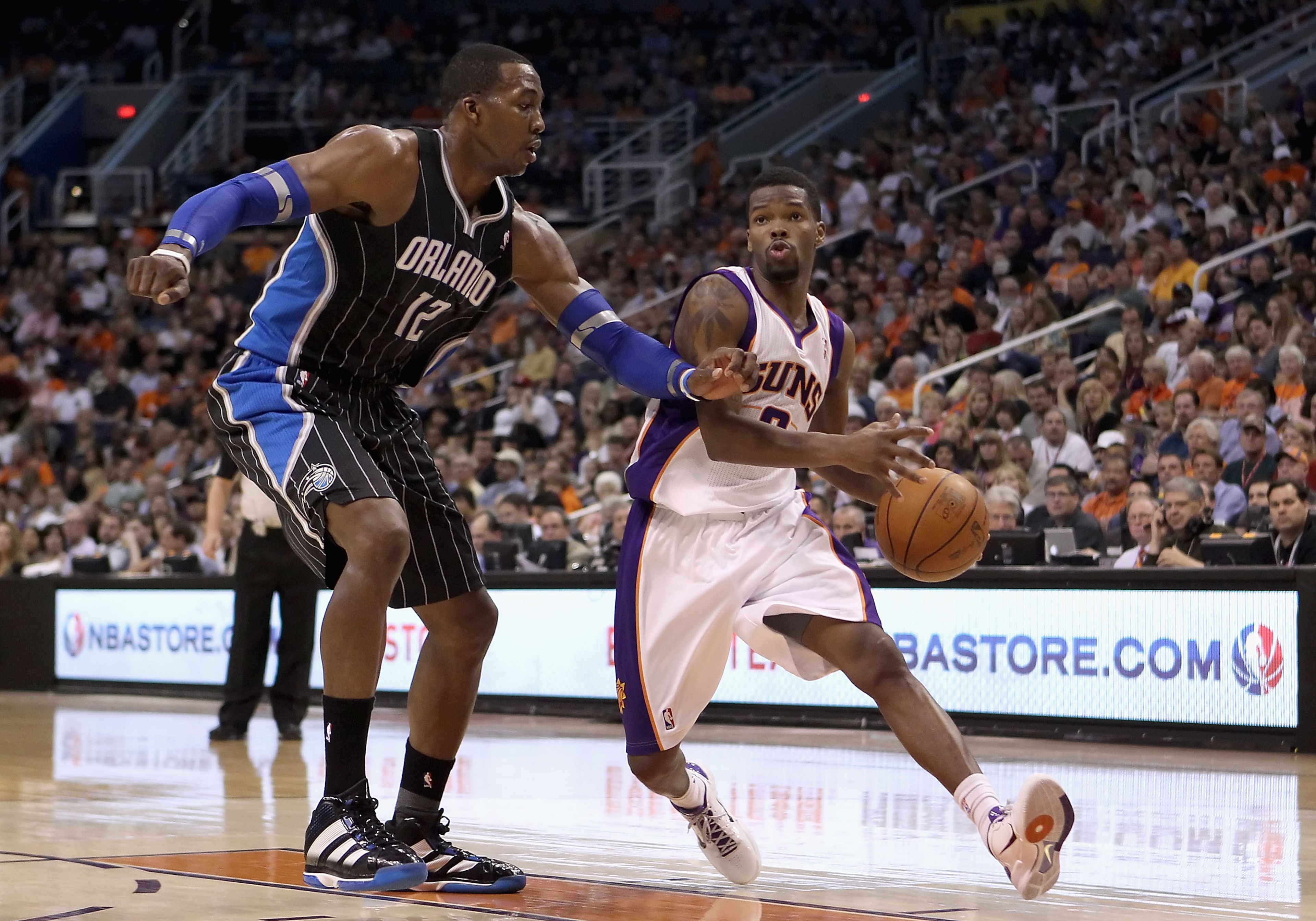 PHOENIX, AZ - MARCH 13:  Aaron Brooks #0 of the Phoenix Suns drives the ball past Dwight Howard #12 of the Orlando Magic during the NBA game at US Airways Center on March 13, 2011 in Phoenix, Arizona.  The Magic defeated the Suns 111-88. NOTE TO USER: Use