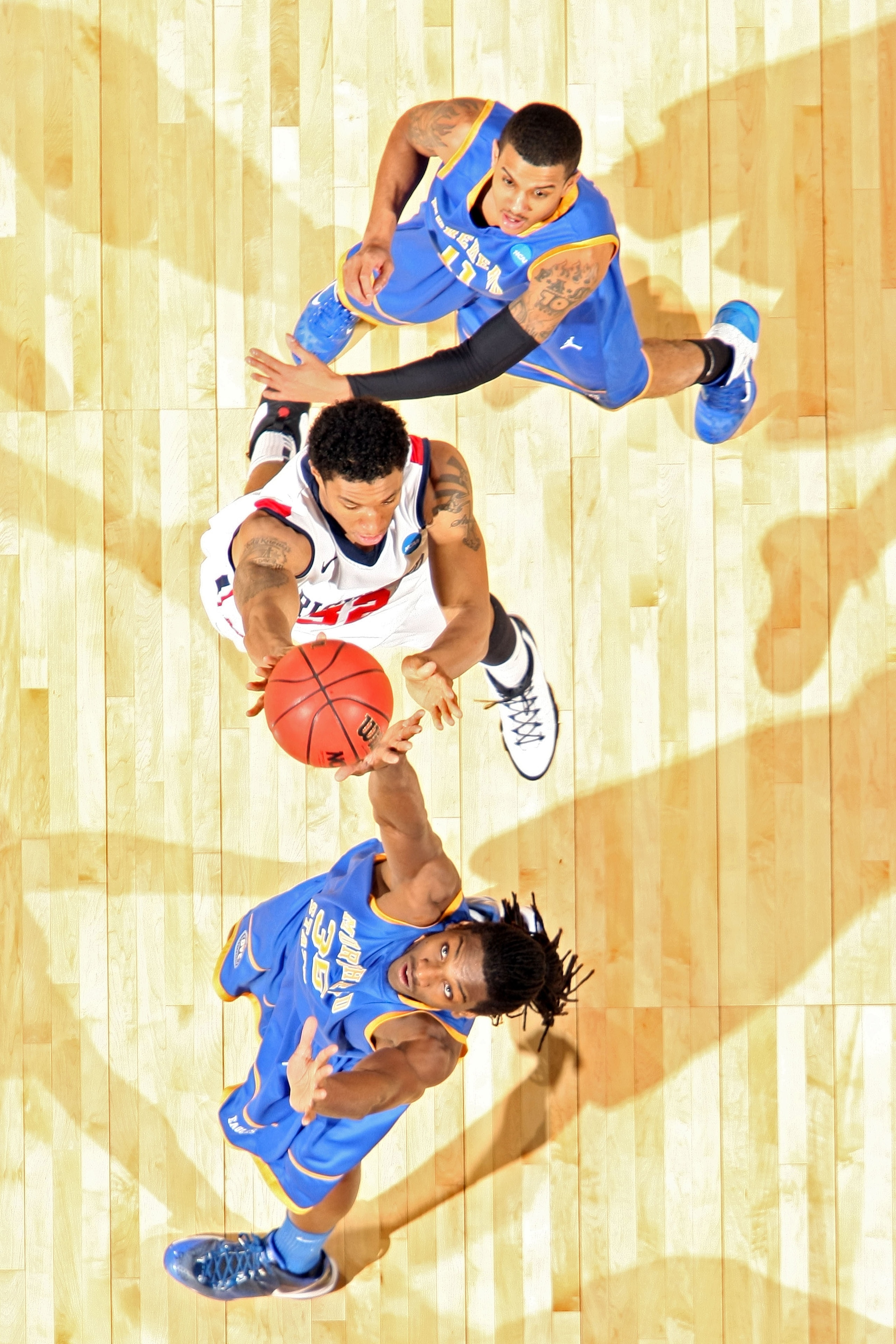 DENVER, CO - MARCH 19: Justin Harper #32 of the Richmond Spiders goes to the hoop against Kenneth Faried #35 and Terrance Hill #11 of the Morehead State Eagles during the third round of the 2011 NCAA men's basketball tournament at Pepsi Center on March 1 DENVER, CO - MARCH 19: Justin Harper #32 of the Richmond Spiders goes to the hoop against Kenneth Faried #35 and Terrance Hill #11 of the Morehead State Eagles during the third round of the 2011 NCAA men's basketball tournament at Pepsi Center on March 1