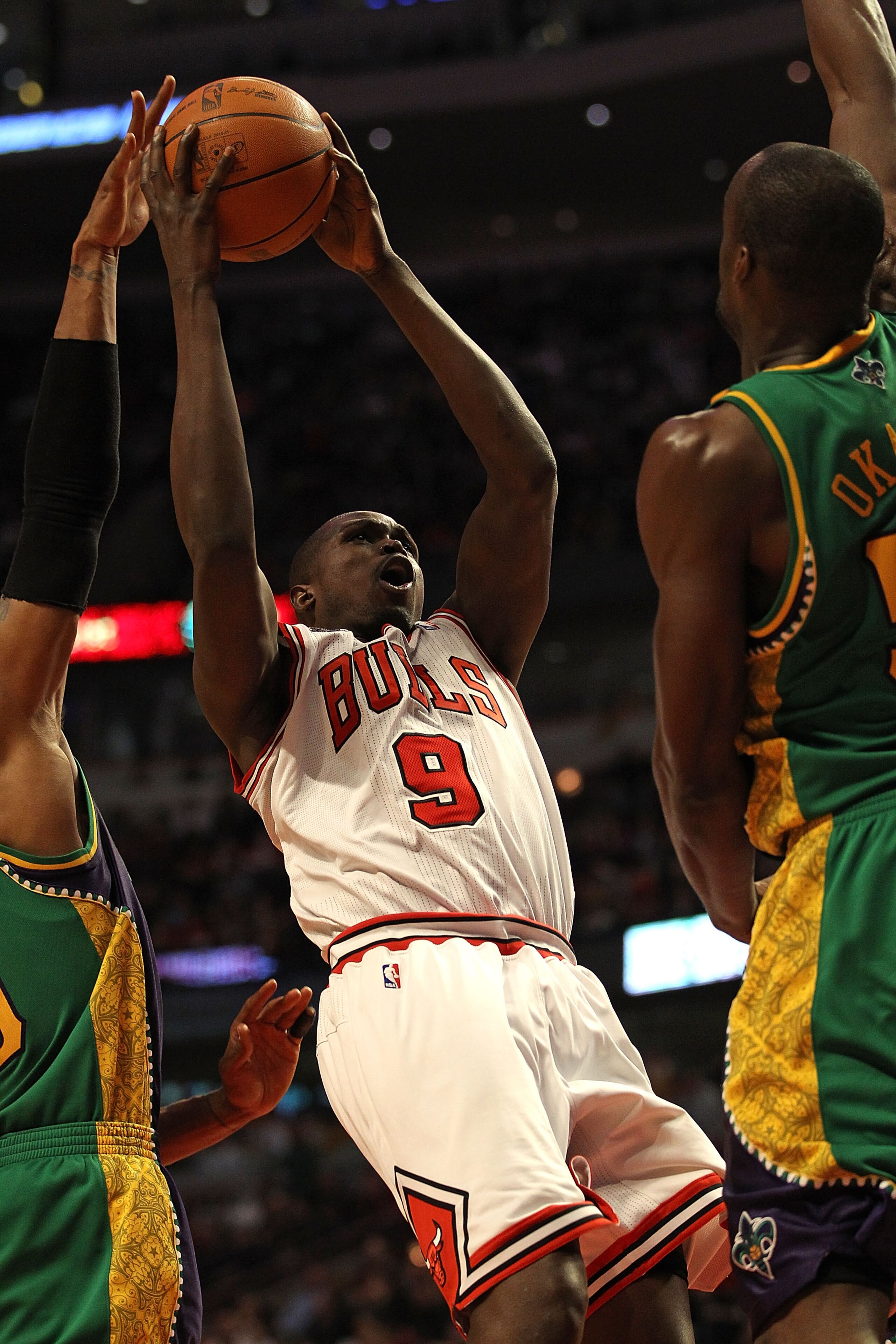 CHICAGO, IL - MARCH 07: Loul Deng #9 of the Chicago Bulls puts up a shot between David West #30 (L) and Emeka Okafor #50 of the New Orleans Hornets at the United Center on March 7, 2011 in Chicago, Illinois. The Bulls defeated the Hornets 85-77. NOTE TO U