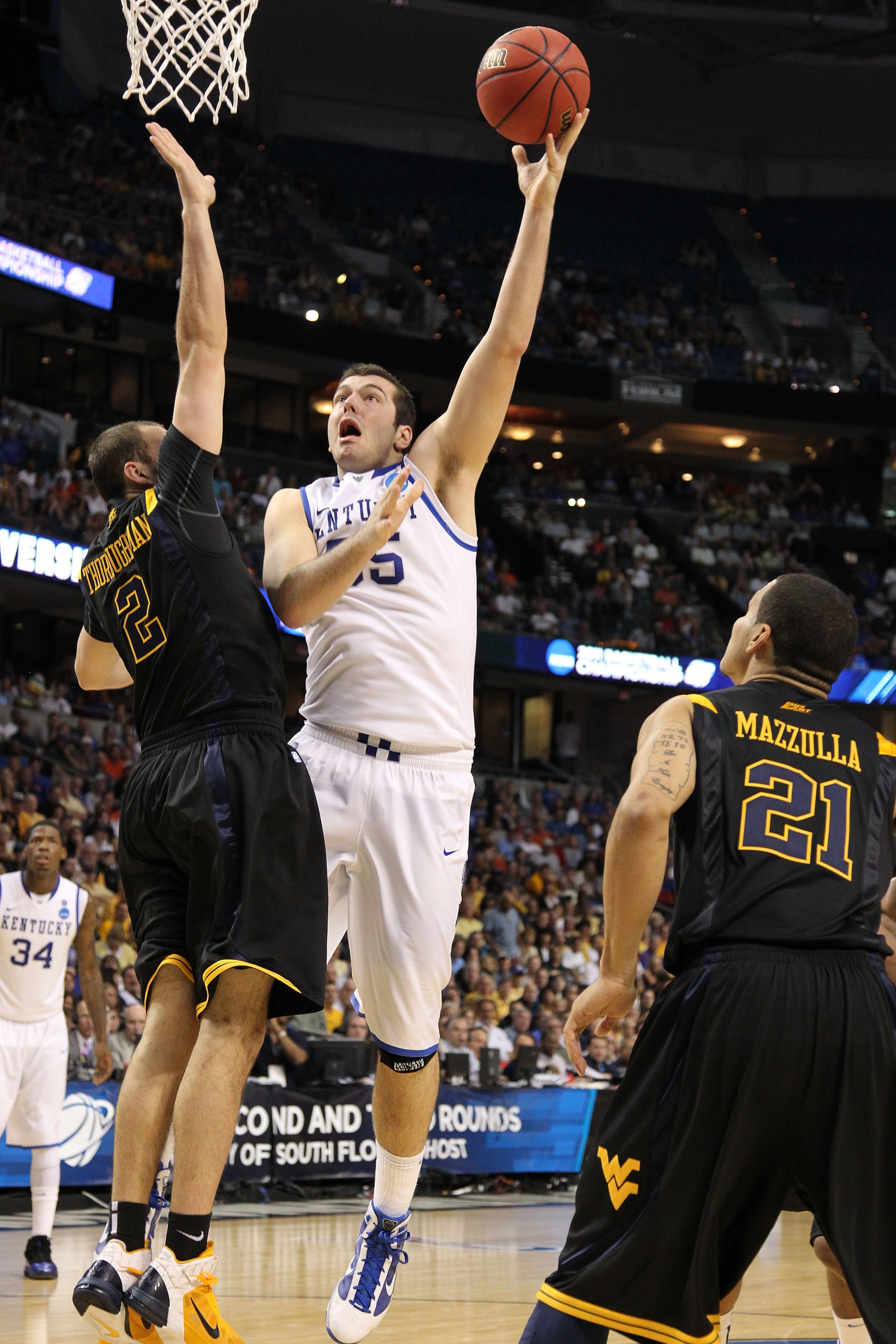 TAMPA, FL - MARCH 19:  Josh Harrellson #55 of the Kentucky Wildcats attempts a shot against Cam Thoroughman #2 of the West Virginia Mountaineers during the third round of the 2011 NCAA men's basketball tournament at St. Pete Times Forum on March 19, 2011