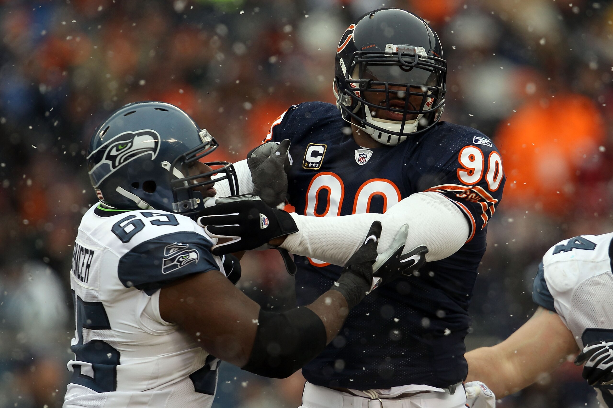 CHICAGO, IL - JANUARY 16:  Julius Peppers #90 of the Chicago Bears is blocked by Chris Spencer #65 of the Seattle Seahawks in the 2011 NFC divisional playoff game at Soldier Field on January 16, 2011 in Chicago, Illinois.  (Photo by Jonathan Daniel/Getty