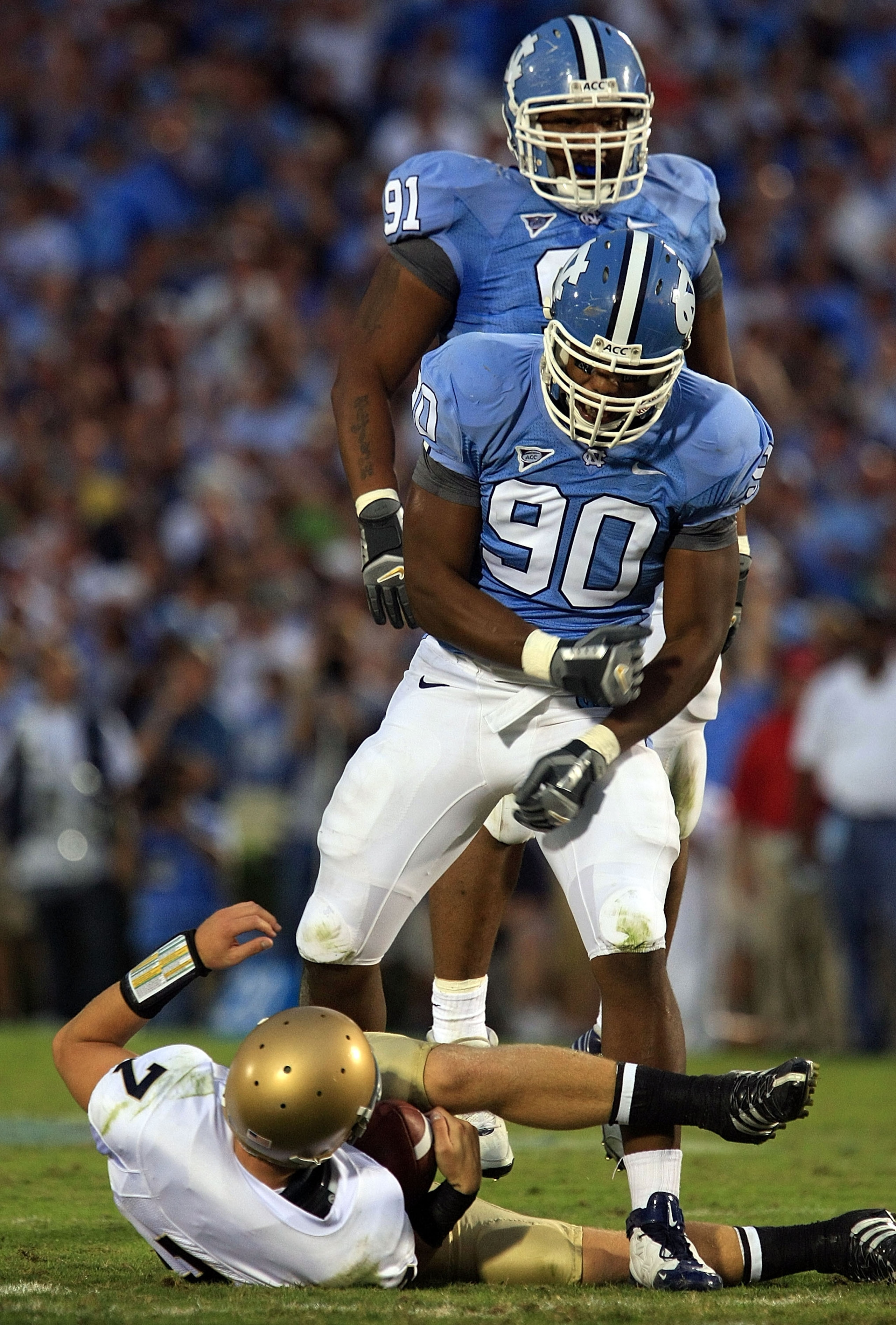 CHAPEL HILL, NC - OCTOBER 11:  Quinton Coples #90 and Tydreke Powell #91 of the North Carolina Tar Heels celebrates after sacking Jimmy Clauson #7 of the Notre Dame Fighting Irish at Kenan Stadium October 11, 2008 in Chapel Hill, North Carolina.  (Photo b
