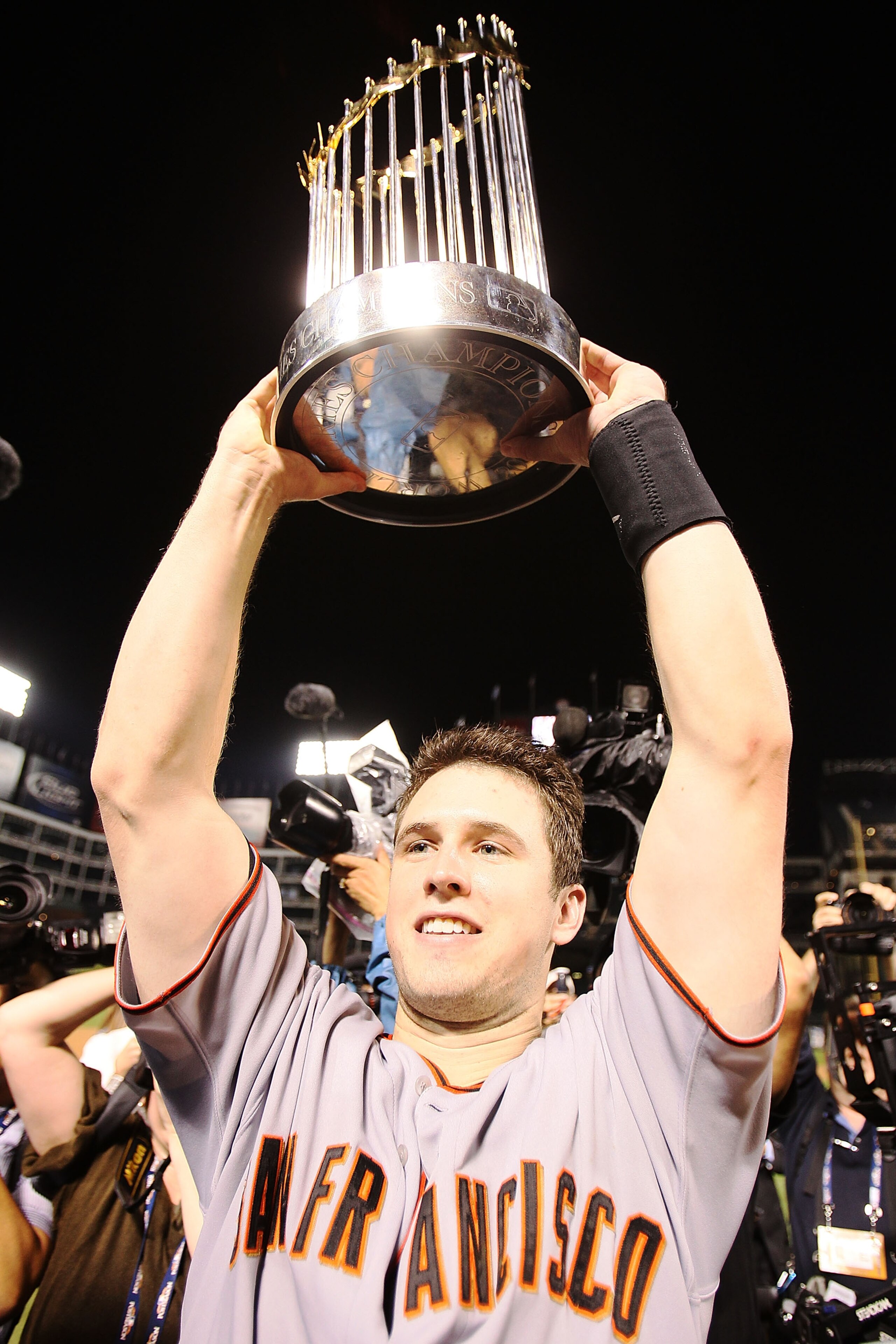 ARLINGTON, TX - NOVEMBER 01: Buster Posey #28 of the San Francisco Giants celebrates with the World Series Championship trophy after the Giants won 3-1 the Texas Rangers in Game Five of the 2010 MLB World Series at Rangers Ballpark in Arlington on Novemb ARLINGTON, TX - NOVEMBER 01: Buster Posey #28 of the San Francisco Giants celebrates with the World Series Championship trophy after the Giants won 3-1 the Texas Rangers in Game Five of the 2010 MLB World Series at Rangers Ballpark in Arlington on Novemb