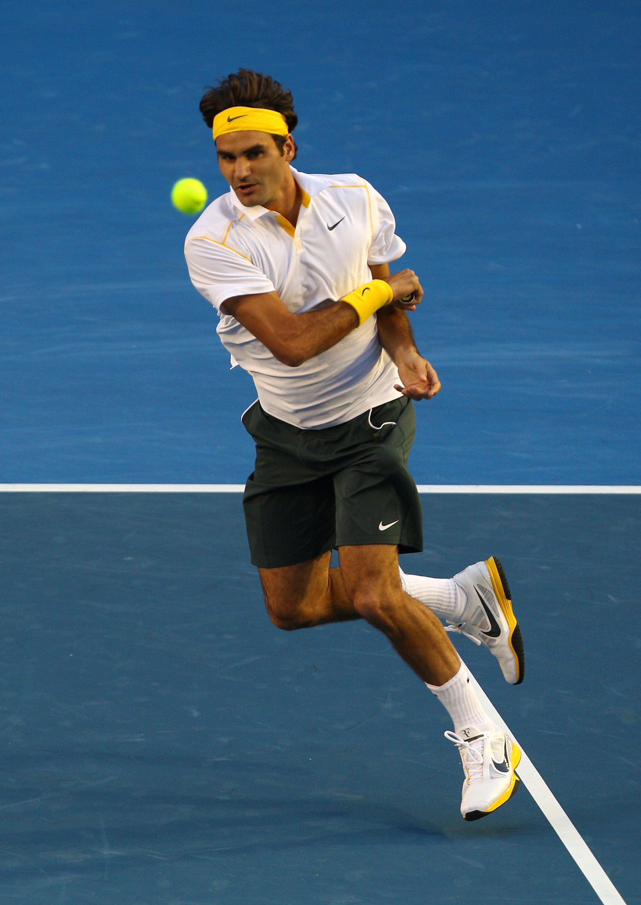 MELBOURNE, AUSTRALIA - JANUARY 27:  Roger Federer of Switzerland plays a forehand in his semifinal match against Novak Djokovic of Serbia during day eleven of the 2011 Australian Open at Melbourne Park on January 27, 2011 in Melbourne, Australia.  (Photo