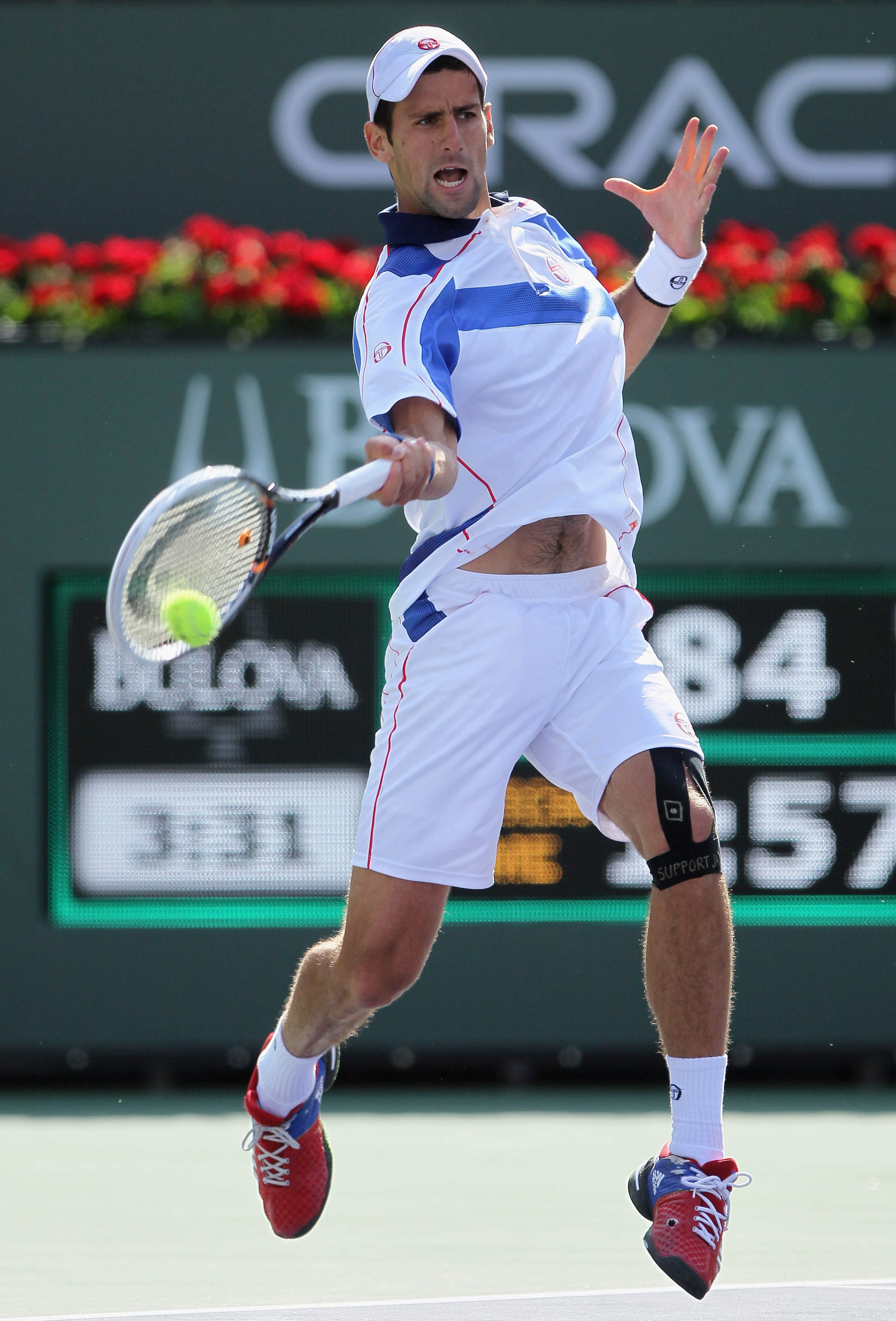 INDIAN WELLS, CA - MARCH 19:  Novak Djokovic of Serbia returns a forehand to Roger Federer of Switzerland during the semifinals of the BNP Paribas Open at the Indian Wells Tennis Garden on March 19, 2011 in Indian Wells, California.  (Photo by Jeff Gross/