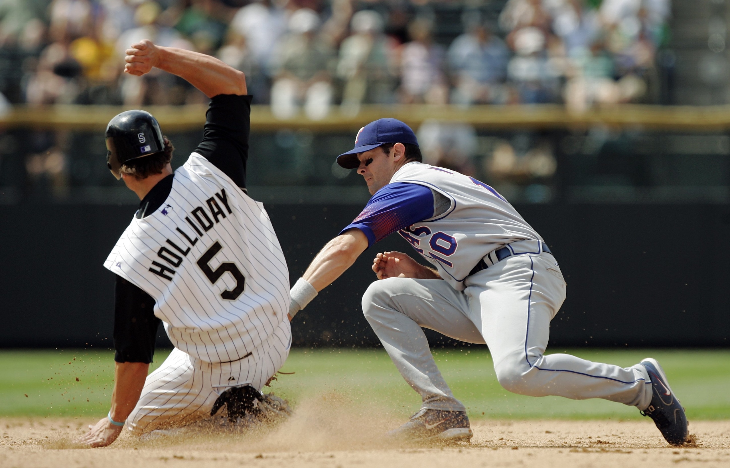 DENVER - JUNE 25:  Shortstop Michael Young #10 of the Texas Rangers tags out Matt Holliday #5 of the Colorado Rockies at second base on a fly out by Garrett Atkins in the eighth inning on June 25, 2006 at Coors Field in Denver, Colorado.  The Rockies won 
