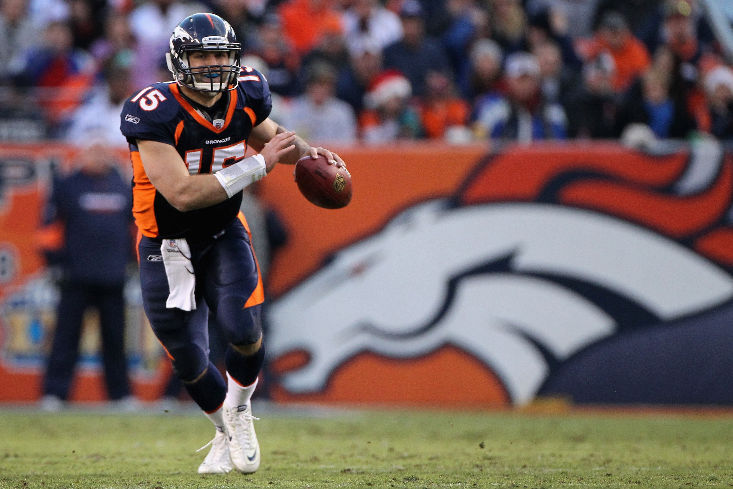 DENVER - DECEMBER 26:  Quarterback Tim Tebow #15 of the Denver Broncos rolls out and looks for a receiver against the Houston Texas at INVESCO Field at Mile High on December 26, 2010 in Denver, Colorado. The Broncos defeated the Texans 24-23.  (Photo by D