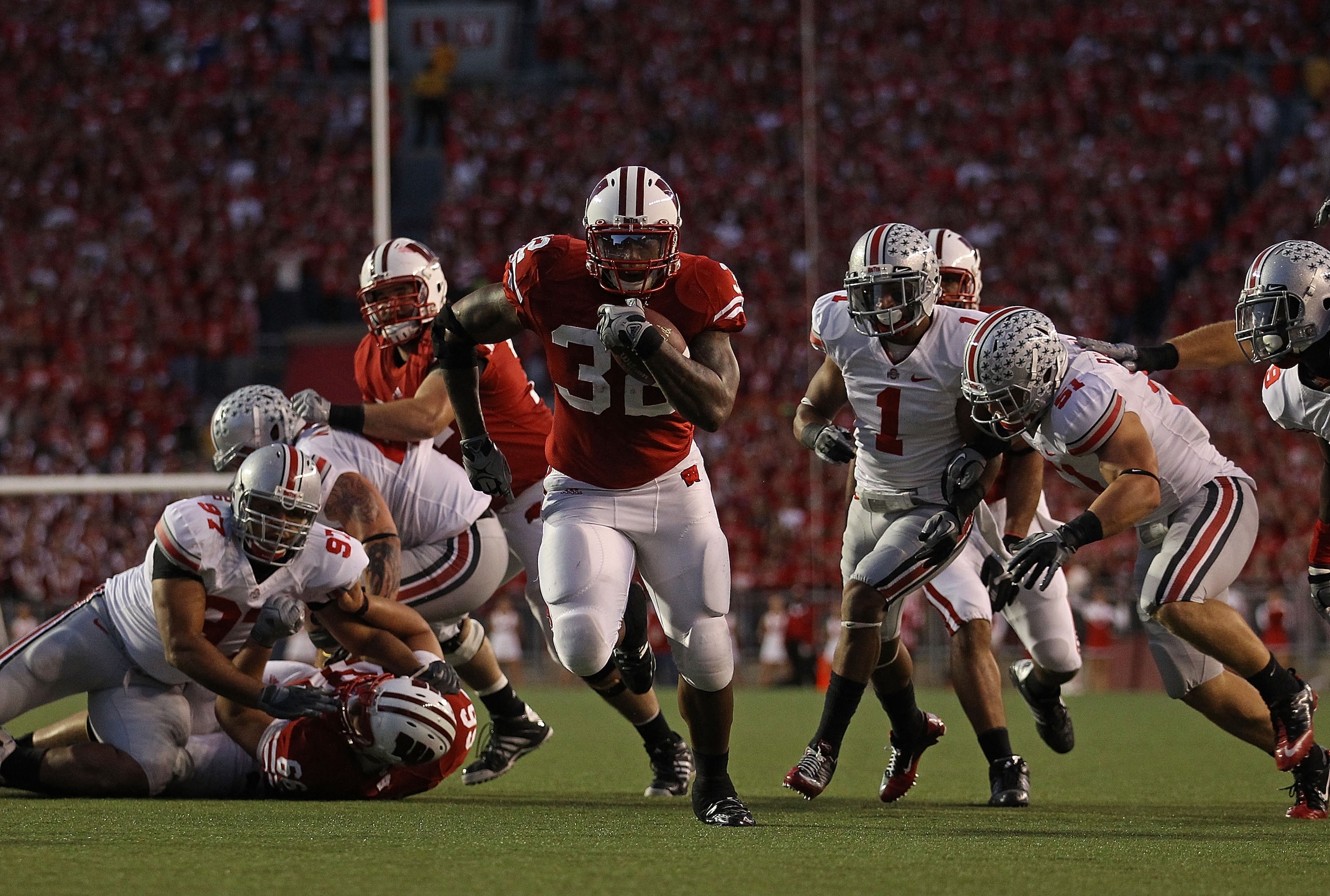 MADISON, WI - OCTOBER 16: John Clay #32 of the Wisconsin Badgers runs past Ross Homan #51 and Devon Torrence #1 of the Ohio State Buckeyes for a touchdown at Camp Randall Stadium on October 16, 2010 in Madison, Wisconsin. (Photo by Jonathan Daniel/Getty I MADISON, WI - OCTOBER 16: John Clay #32 of the Wisconsin Badgers runs past Ross Homan #51 and Devon Torrence #1 of the Ohio State Buckeyes for a touchdown at Camp Randall Stadium on October 16, 2010 in Madison, Wisconsin. (Photo by Jonathan Daniel/Getty I