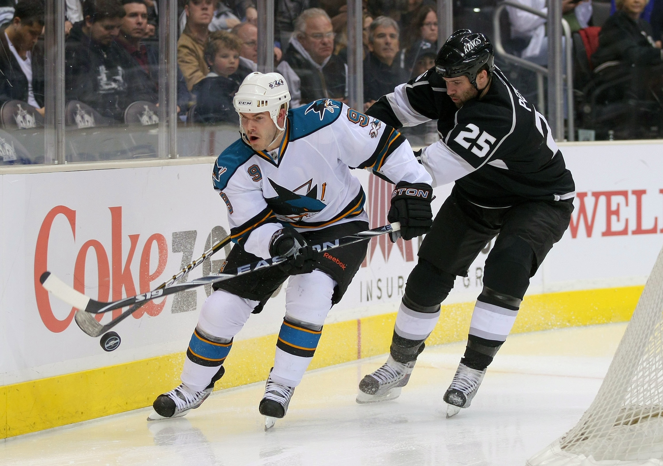 LOS ANGELES, CA - MARCH 24:  Dustin Penner #25 of the Los Angeles Kings forechecks the play of Ian White #9 of the San Jose Sharks in the second period during the NHL game at Staples Center on March 24, 2011 in Los Angeles, California.  (Photo by Victor D