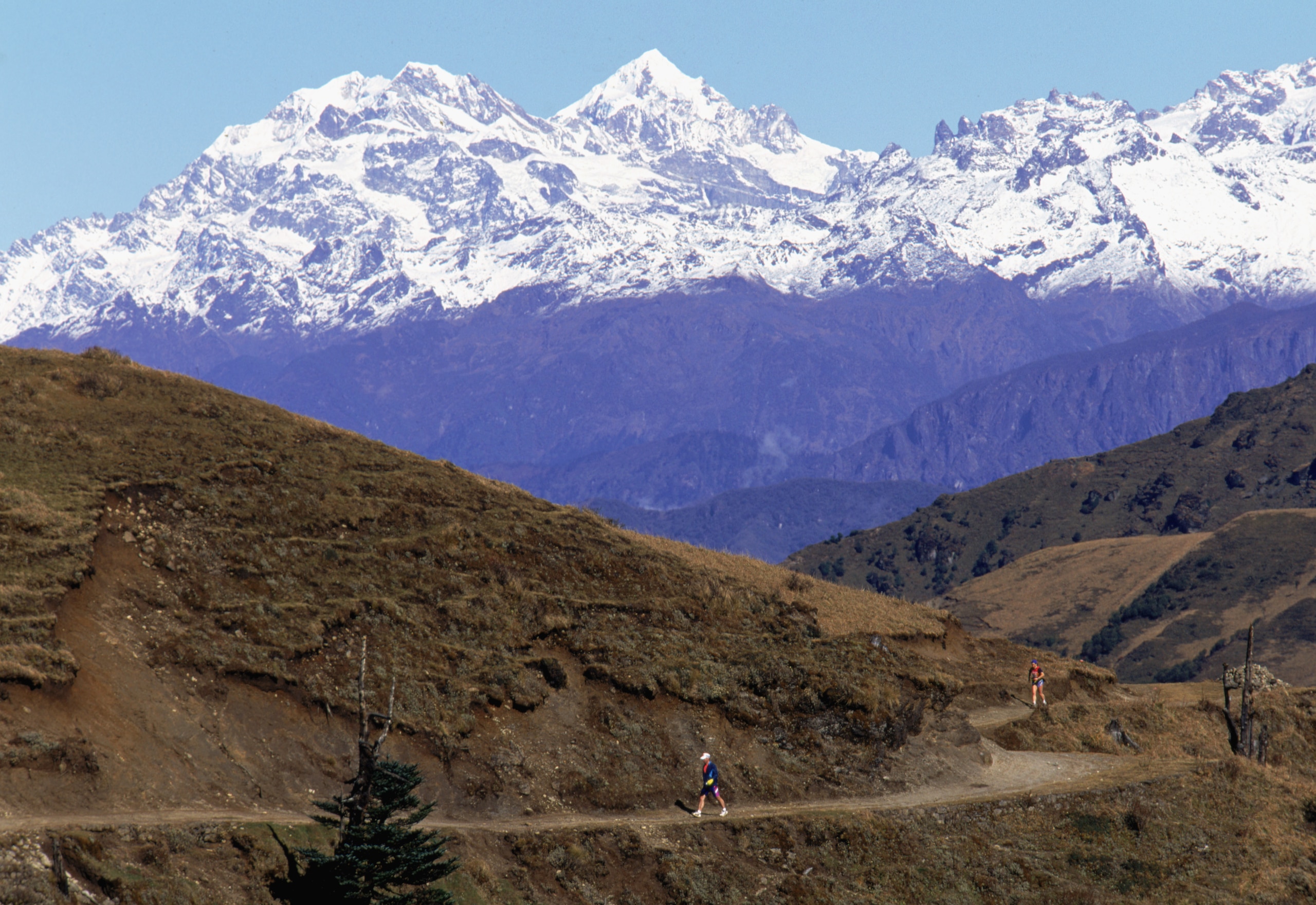 DARJEELING - NOVEMBER: Runners traverse the route during the Mount Everest Challenge Marathon which winds past spectacular views of Everest and Kanchenjunga at Sandakphu National Park in the month of November 1995 near Darjeeling, India. DARJEELING - NOVEMBER: Runners traverse the route during the Mount Everest Challenge Marathon which winds past spectacular views of Everest and Kanchenjunga at Sandakphu National Park in the month of November 1995 near Darjeeling, India.