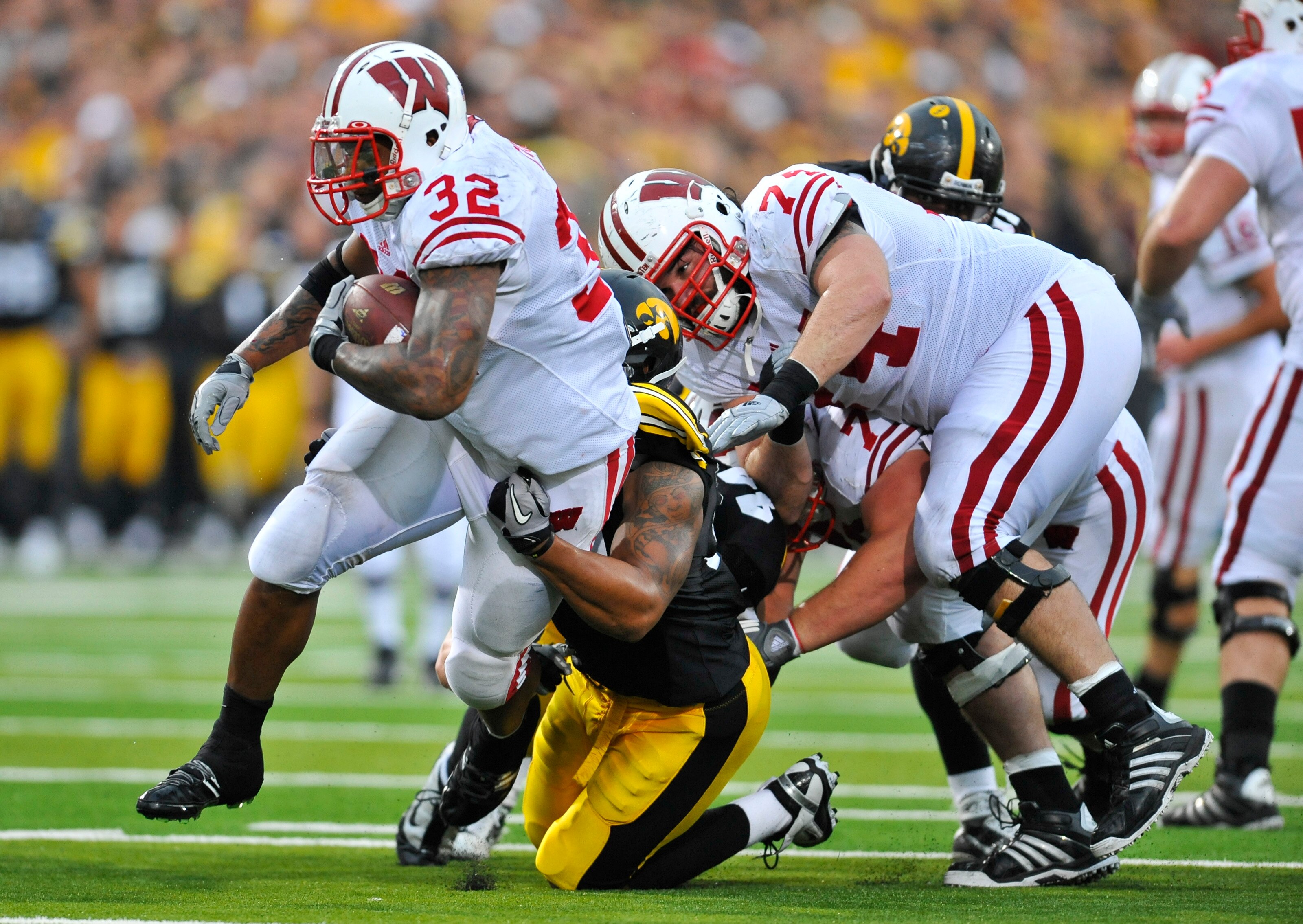 IOWA CITY, IA - OCTOBER 23: Running back John Clay #32 of the Wisconsin Badgers is tackled by line backer Lance Tillison #50 of the  University of Iowa Hawkeyes as he drove the ball up the middle of the Wisconsin Badgers during the second half of play at
