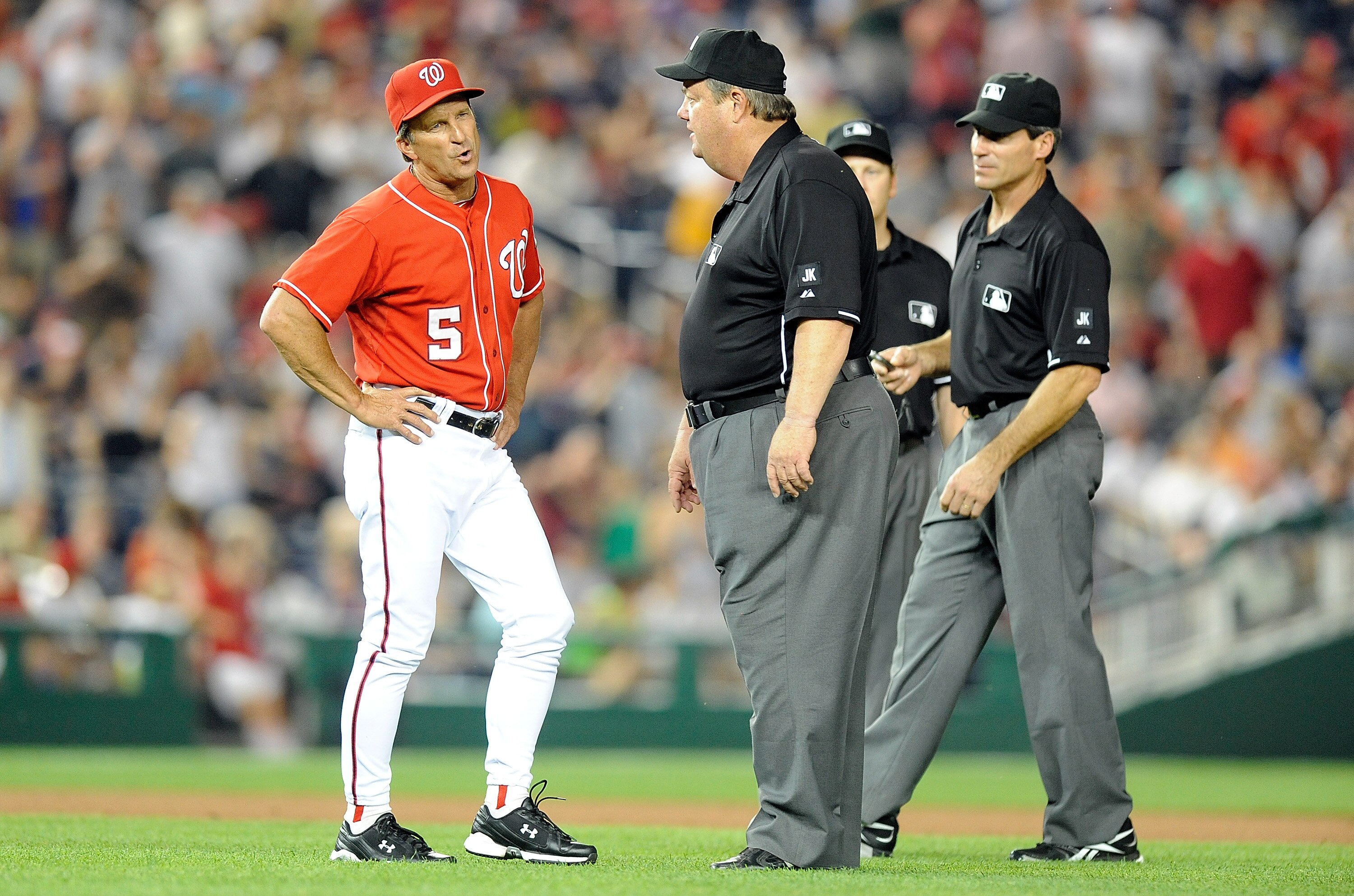 WASHINGTON - JUNE 04:  Manager Jim Riggleman of the Washington Nationals argues with first base umpire Joe West, second base umpire Angel Hernandez and third base umpire Paul Schrieber after a call in the seventh inning of the game against the Cincinnati