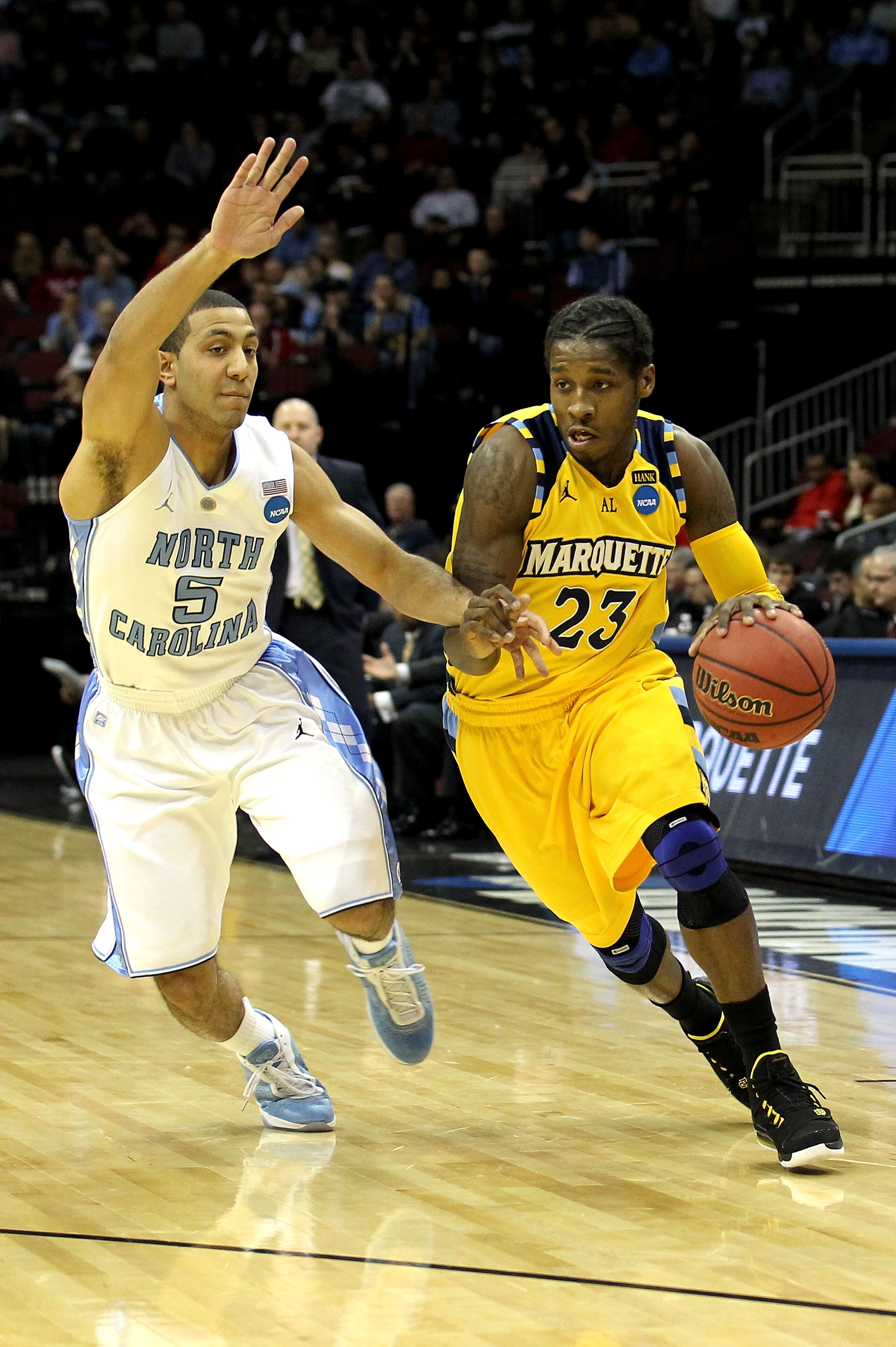 NEWARK, NJ - MARCH 25:  Dwight Buycks #23 of the Marquette Golden Eagles goes for a layup gainats Kendall Marshall #5 of the North Carolina Tar Heels during the east regional semifinal of the 2011 NCAA Men's Basketball Tournament at the Prudential Center 