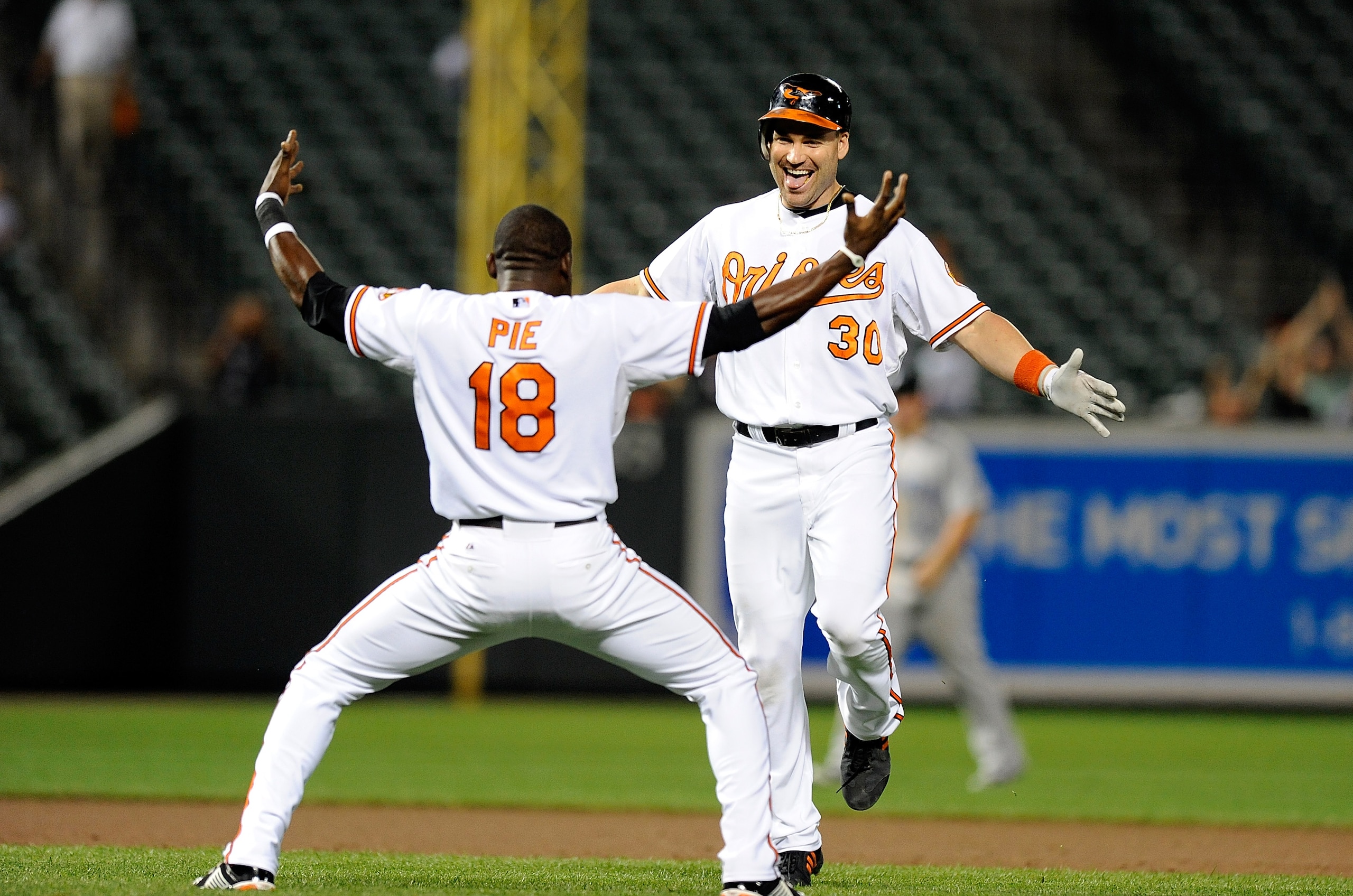BALTIMORE - SEPTEMBER 13:  Luke Scott #30 of the Baltimore Orioles celebrates with Felix Pie #18 after driving in the game winning run in the eleventh inning against the Toronto Blue Jays at Camden Yards on September 13, 2010 in Baltimore, Maryland. The O