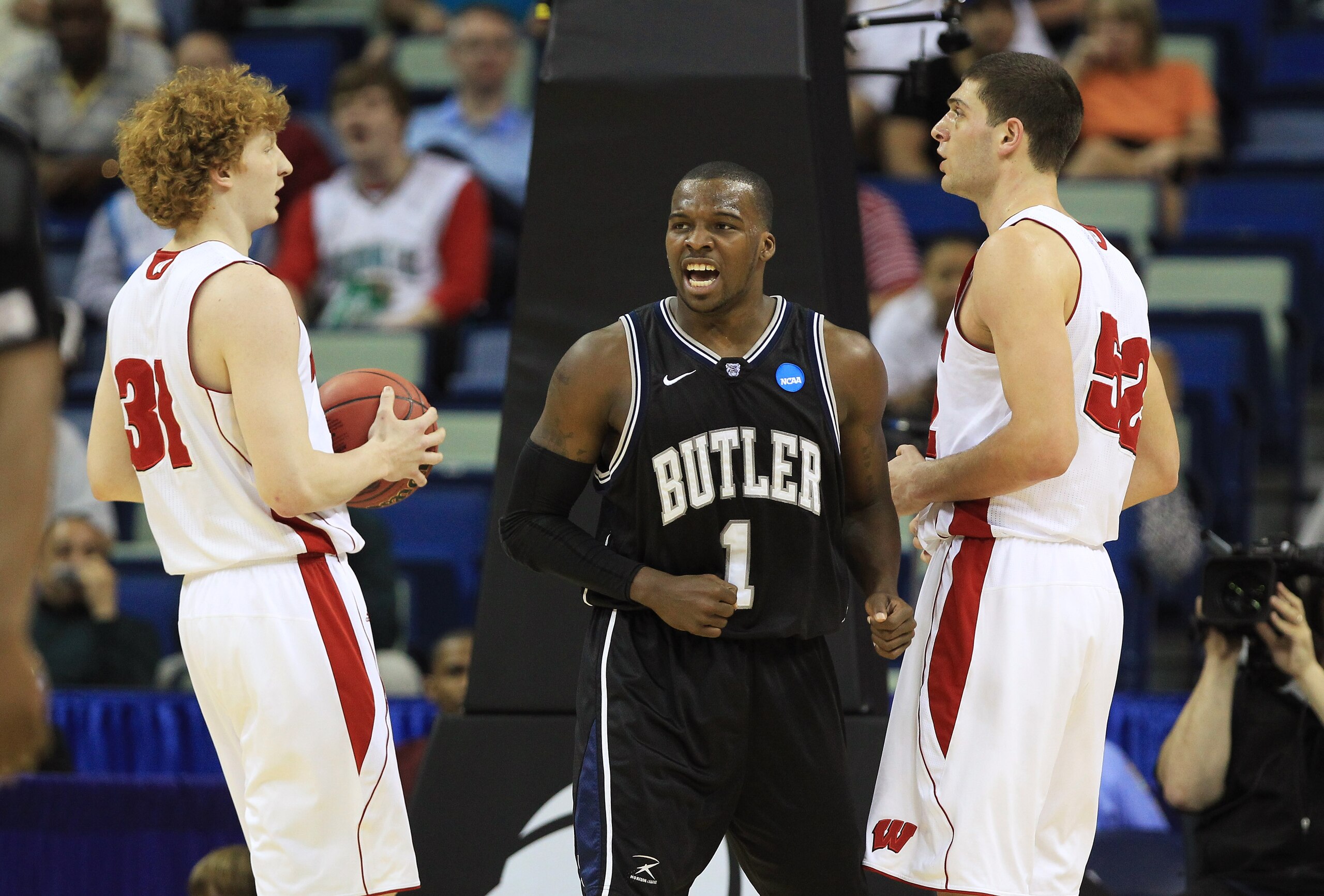 NEW ORLEANS, LA - MARCH 24:  Shelvin Mack #1 of the Butler Bulldogs reacts as Mike Bruesewitz #31 and Keaton Nankivil #52 of the Wisconsin Badgers look on during the Southeast regional of the 2011 NCAA men's basketball tournament at New Orleans Arena on M