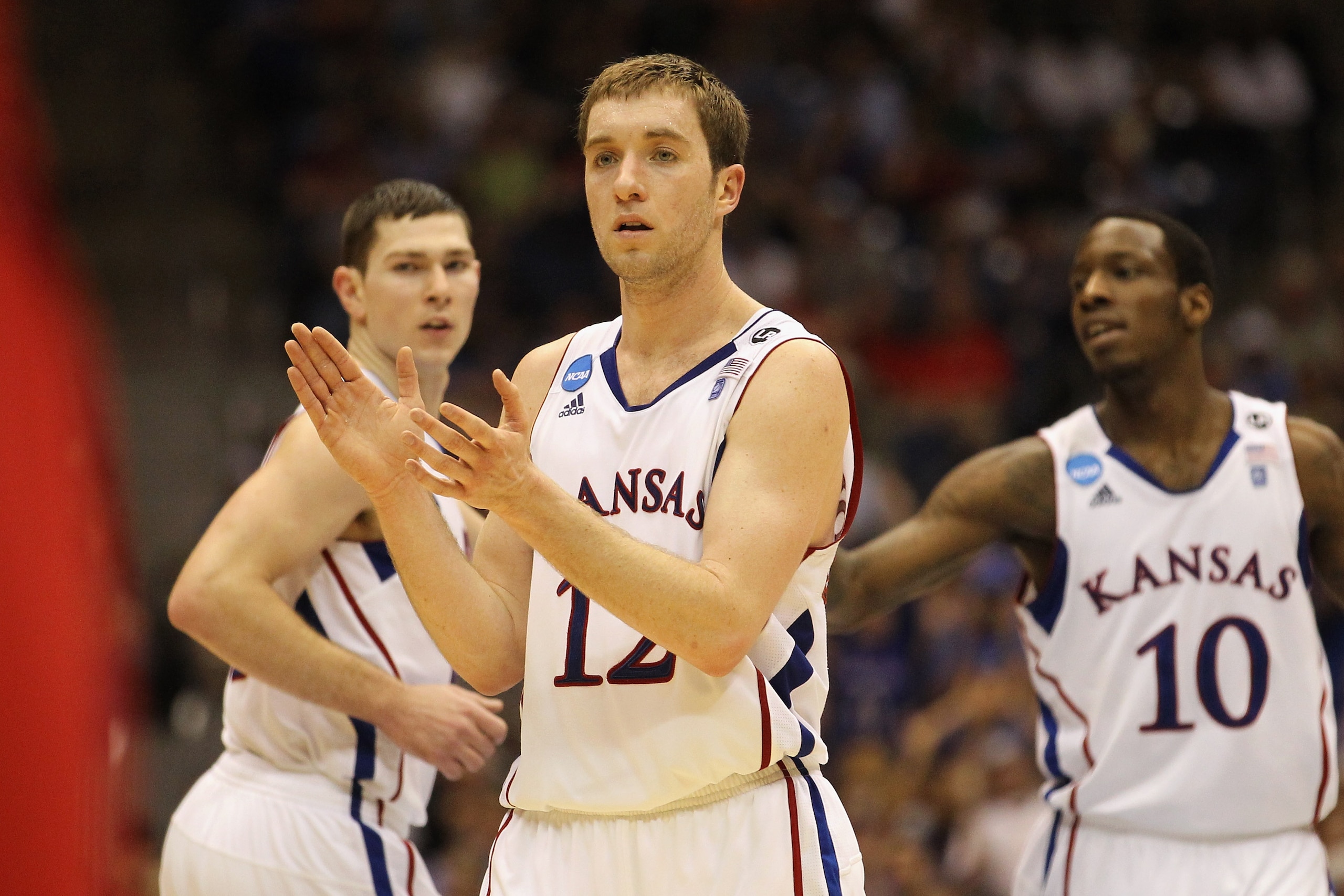 SAN ANTONIO, TX - MARCH 25:  (L-R) Tyrel Reed #14, Brady Morningstar #12 and Tyshawn Taylor #10 of the Kansas Jayhawks react during the southwest regional of the 2011 NCAA men's basketball tournament against the Richmond Spiders at the Alamodome on March