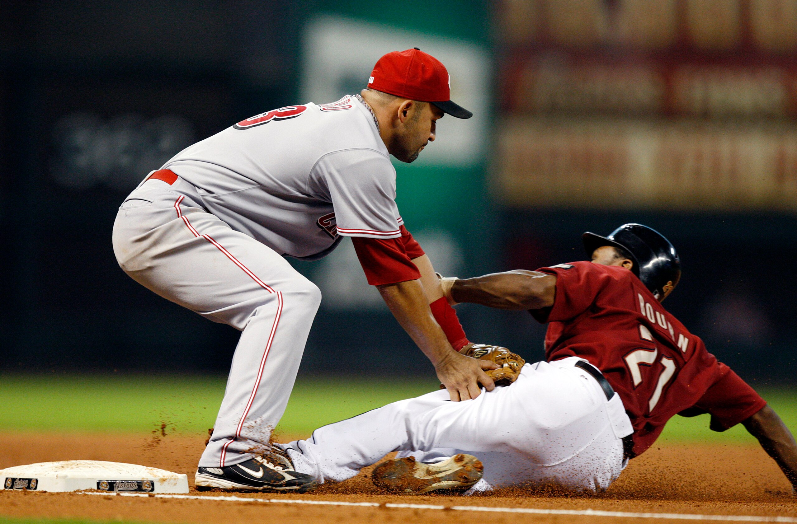 HOUSTON - SEPTEMBER 19:  Michael Bourtn #21 of the Houston Astros is tagged out at third base by Miguel Cairo #43 on a fielders choice against the Cincinnatti Reds at Minute Maid Park on September 19, 2010 in Houston, Texas.  (Photo by Bob Levey/Getty Ima