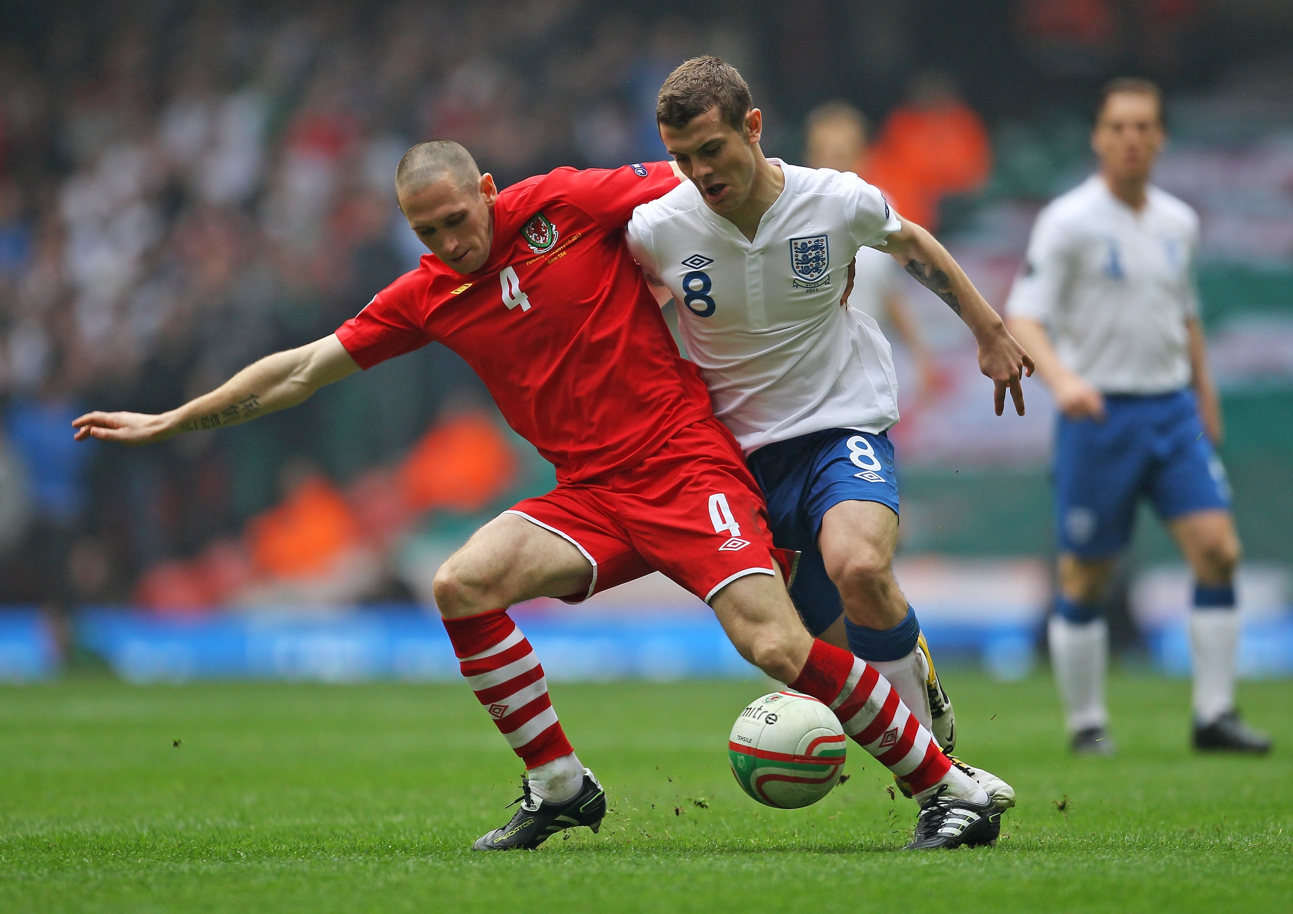 CARDIFF, WALES - MARCH 26:  Jack Wilshere of England is challenged by Andrew Crofts of Wales during the UEFA EURO 2012 Group G qualifying match between Wales and England at the Millennium Stadium on March 26, 2011 in Cardiff, Wales.  (Photo by Alex Livese